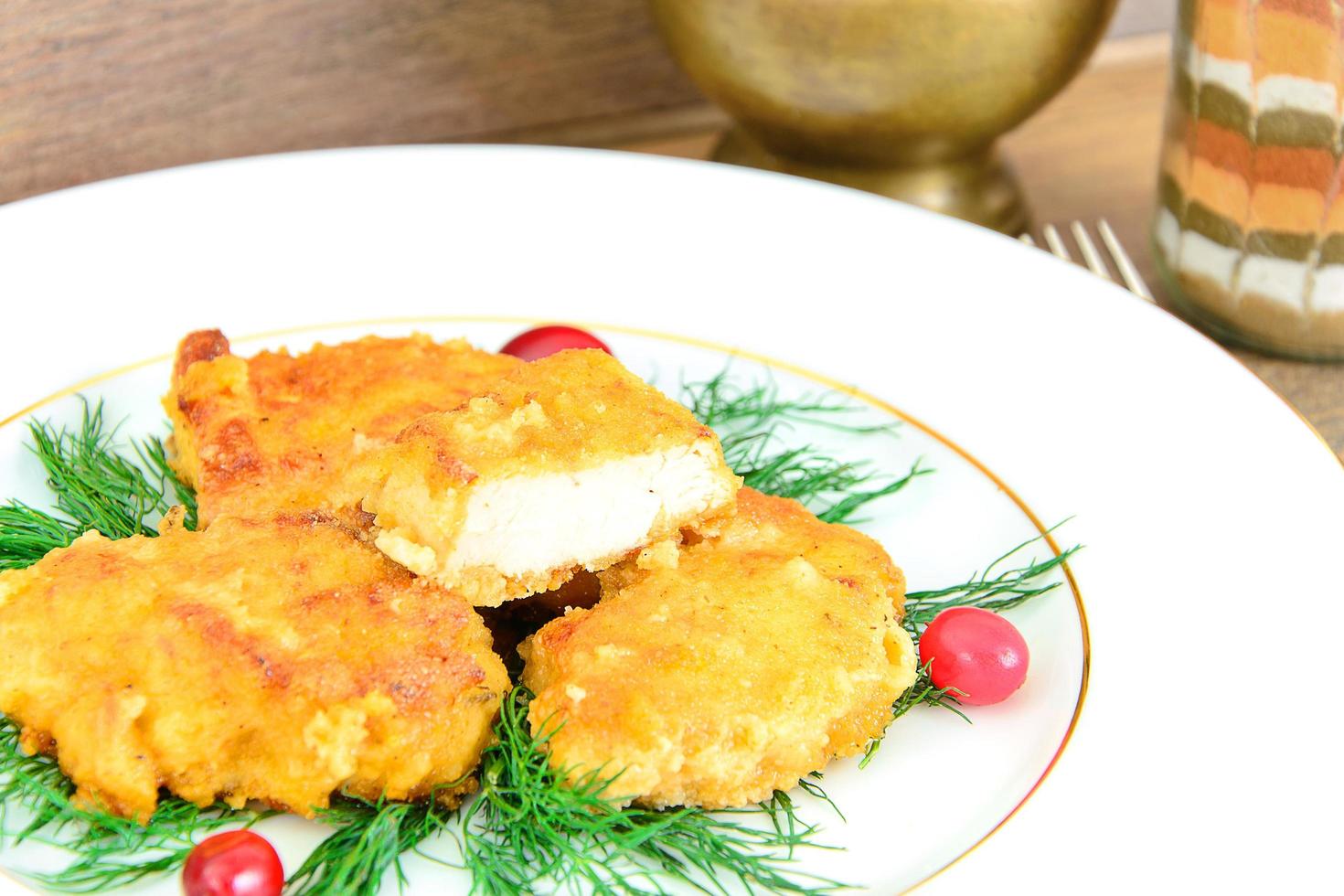 filetto di pollo impanato con erbe e mirtilli rossi. foto