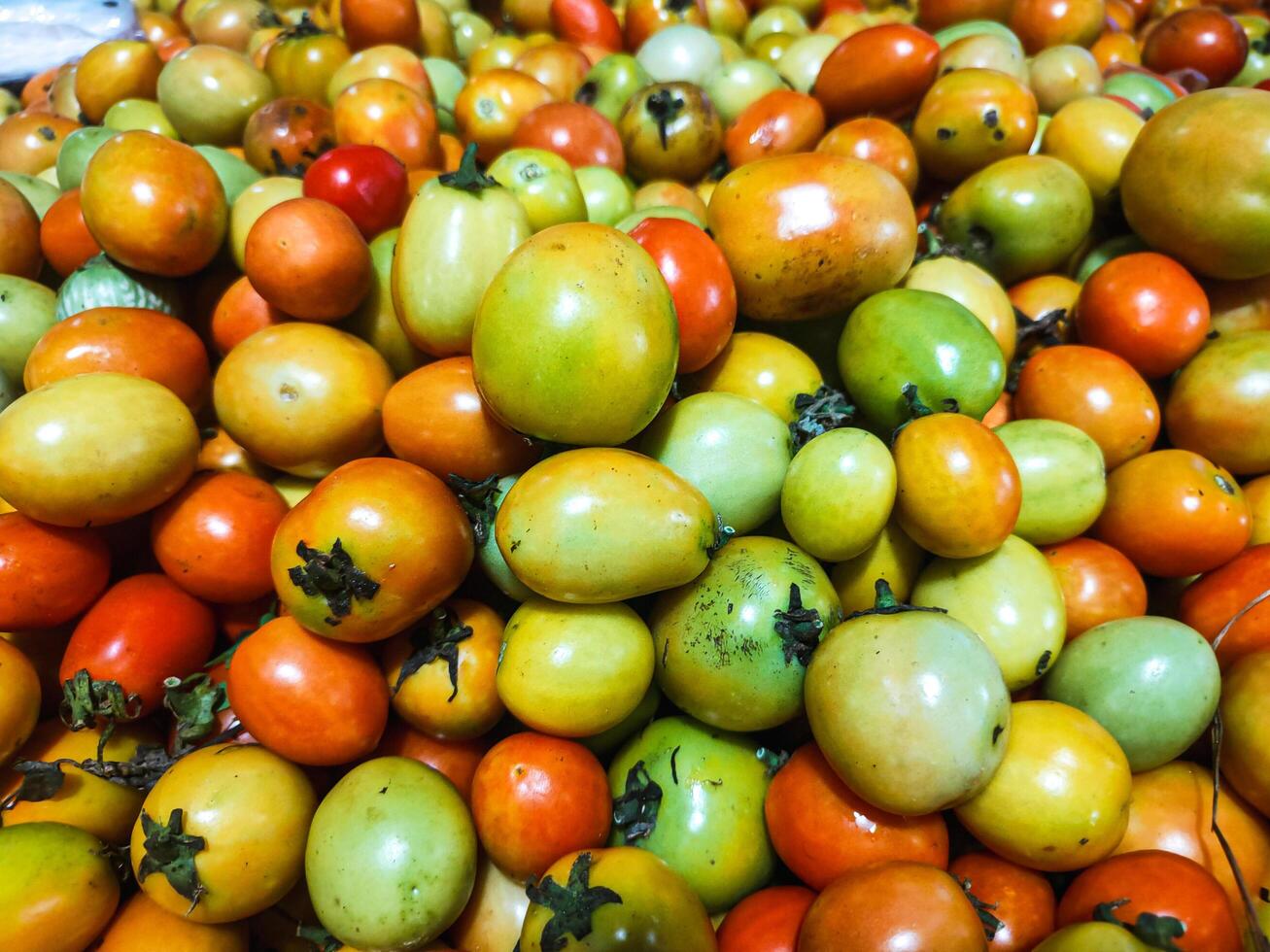 fotografia di vicino su struttura sfondo di mucchio di pomodori foto