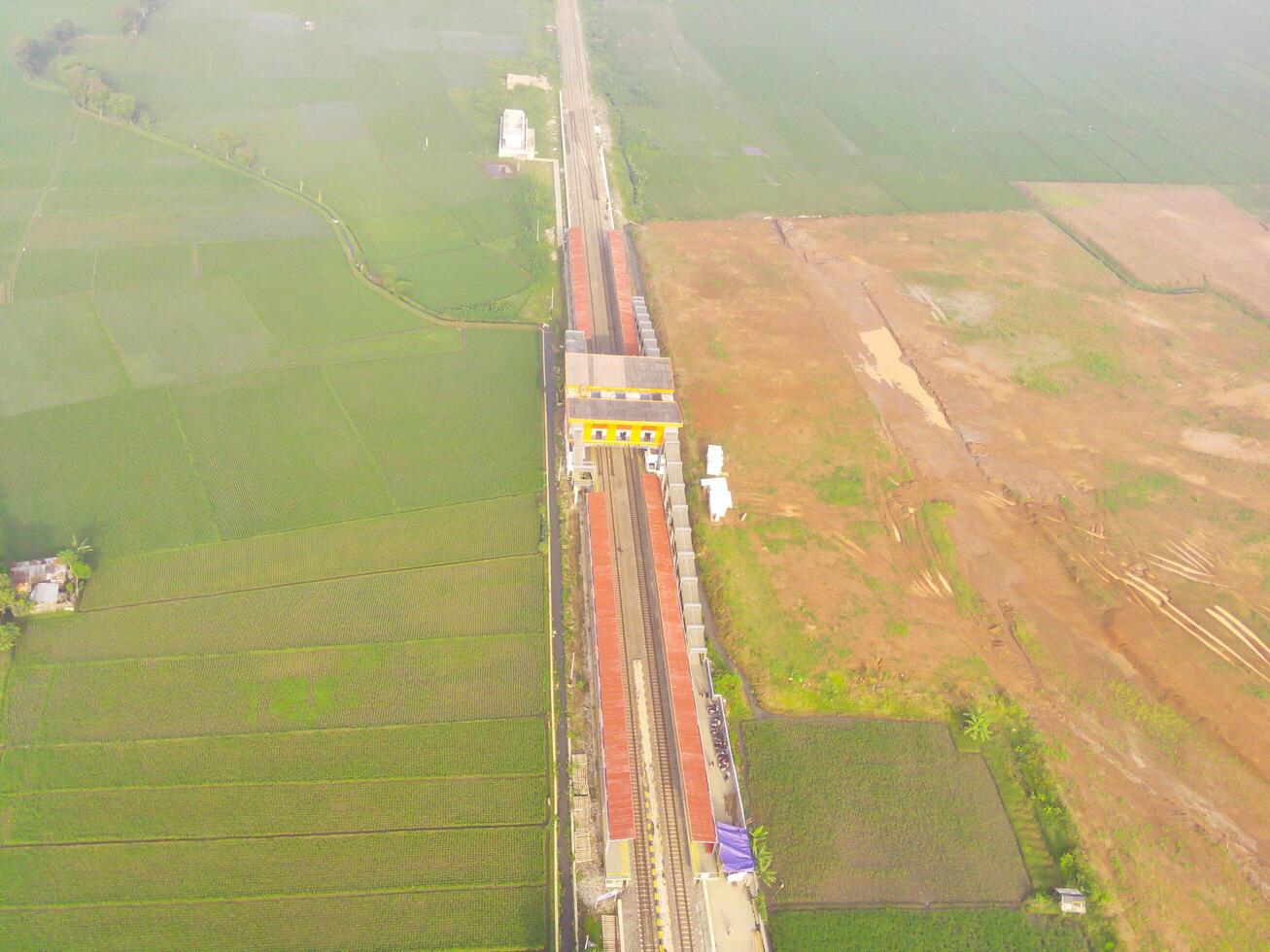 nebbioso Visualizza di il ferrovia linea. aereo Visualizza di treno traccia e stazione nel rancaekek, bandung - Indonesia. naturale condizioni. sopra. pubblico trasporto. tiro nel fuco volante 100 metri foto