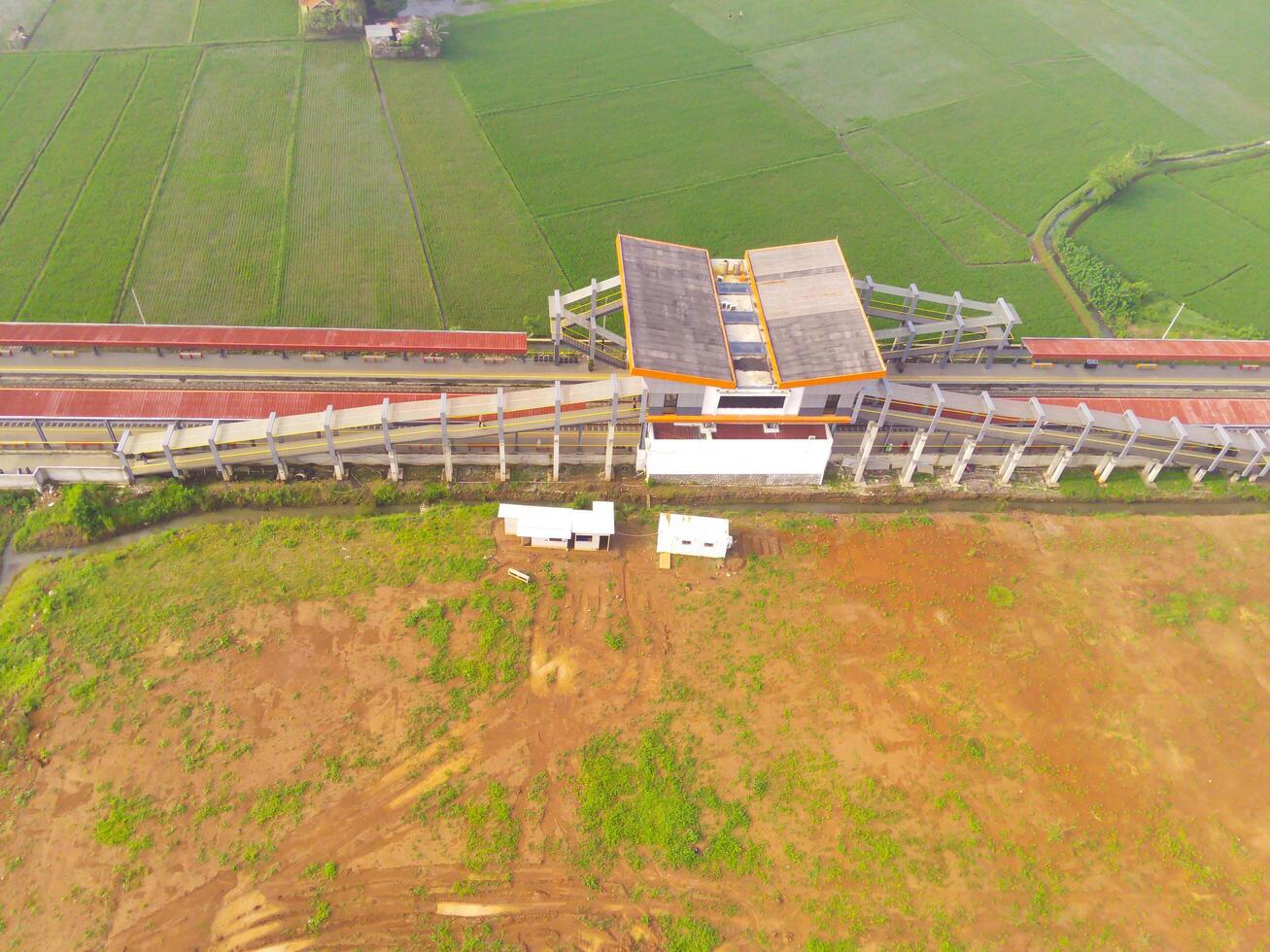 nebbioso Visualizza di il ferrovia stazione. aereo Visualizza di treno traccia e stazione nel rancaekek, bandung - Indonesia. naturale condizioni. sopra. pubblico trasporto. tiro nel fuco volante 100 metri foto