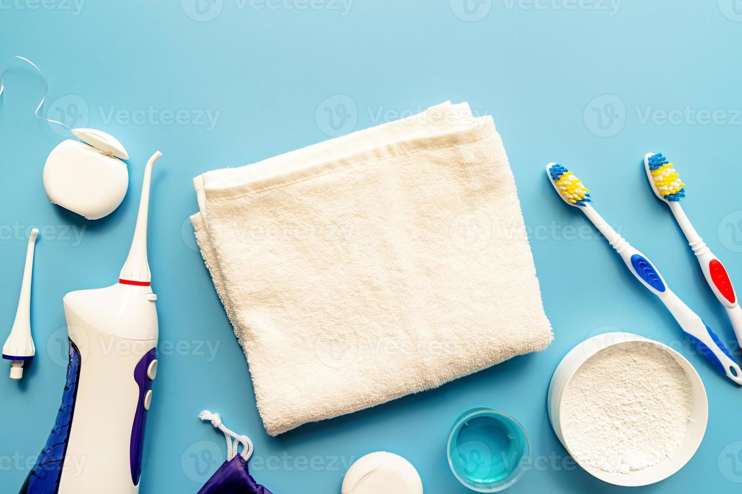 strumenti dentali, filo interdentale, irrigatore della bocca, spazzolini da denti e vista dall'alto di polvere di denti su sfondo blu foto