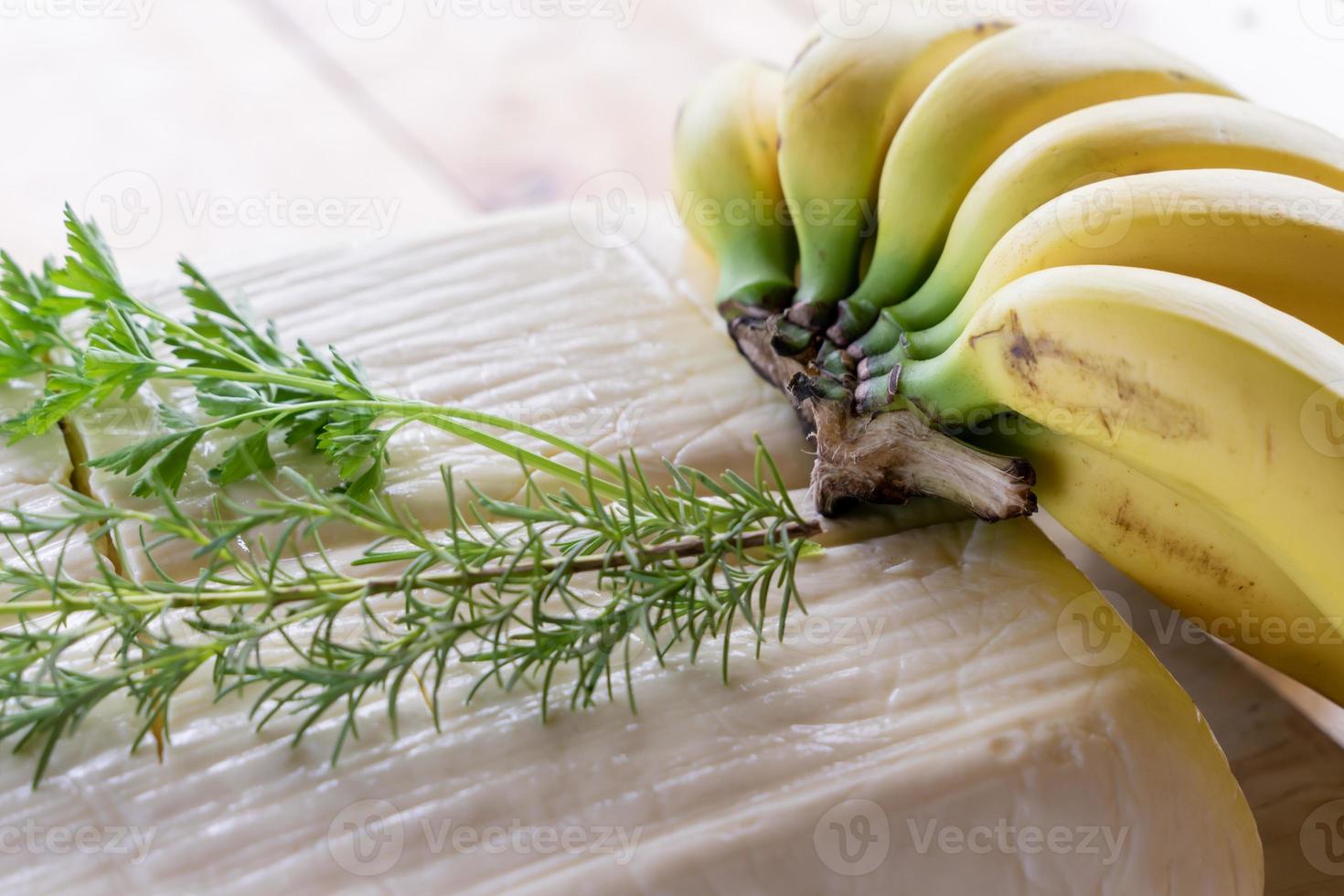 formaggio fresco grande con erbe fresche e banane foto