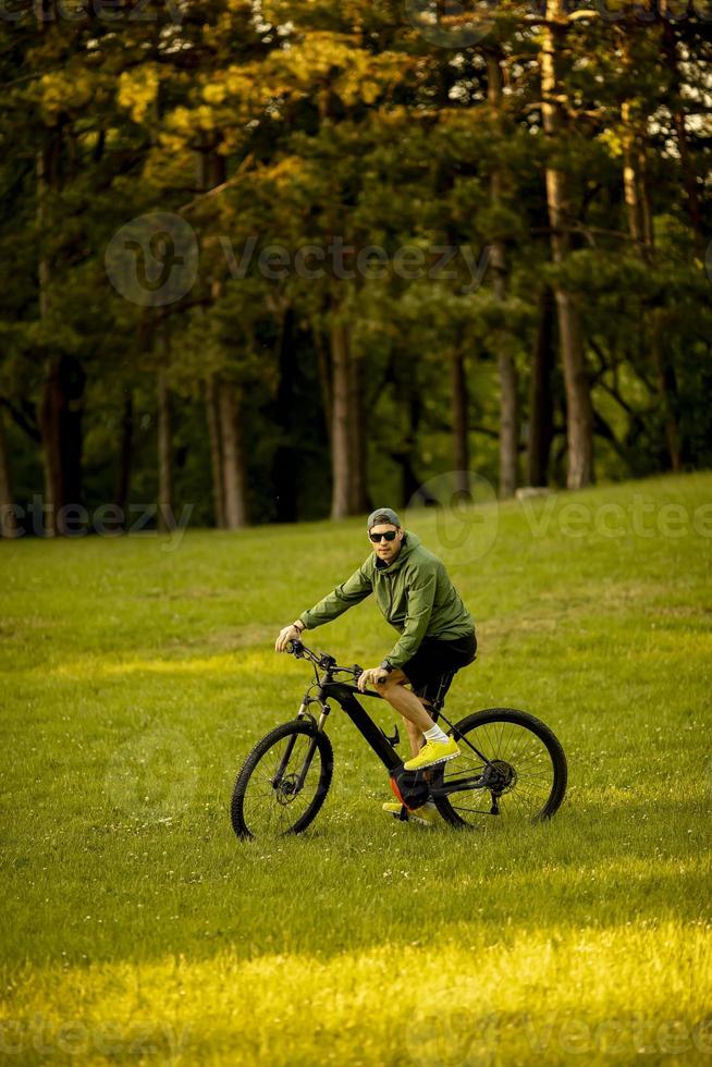 giovane in sella a ebike nel parco foto