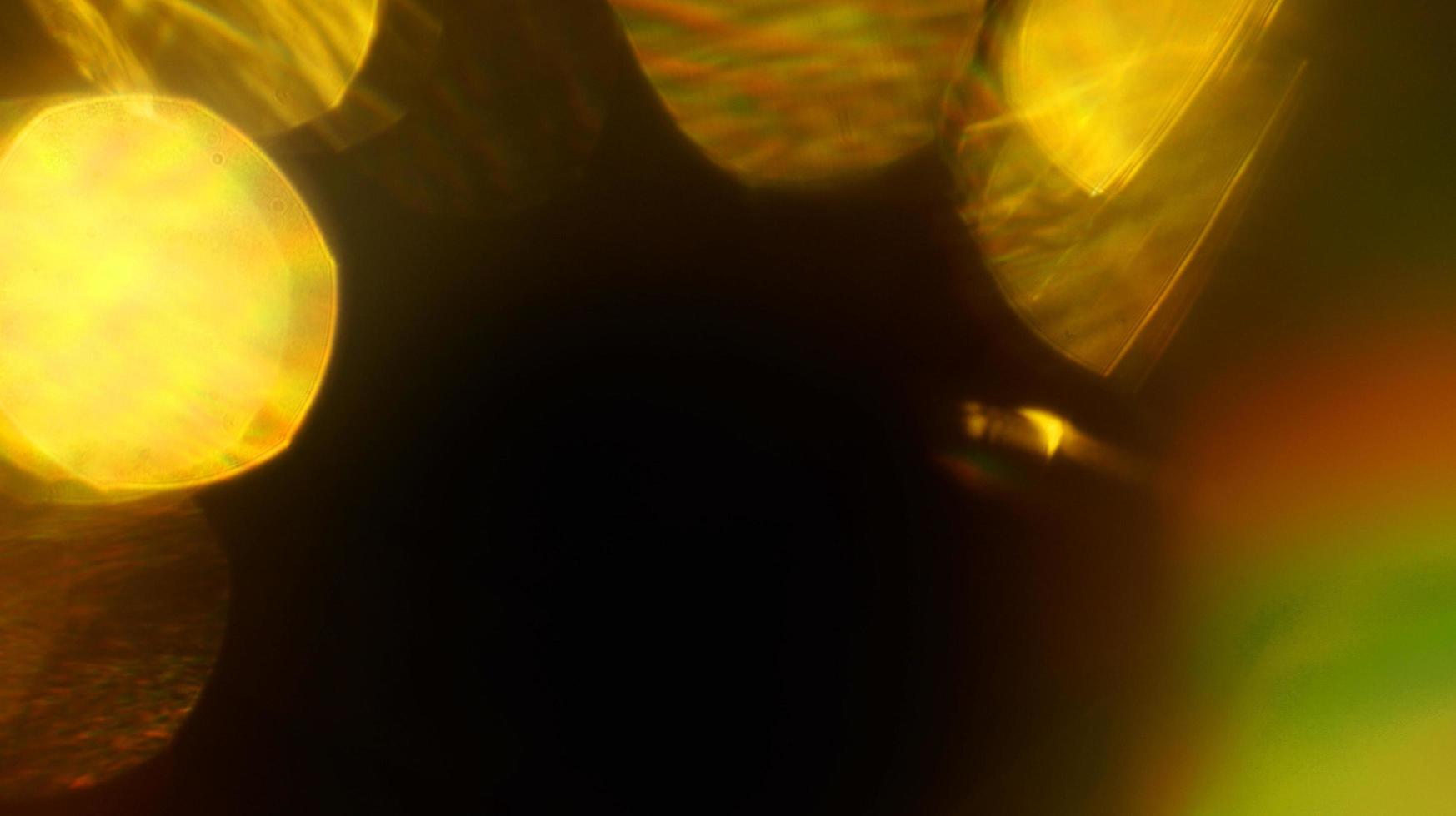 arcobaleno giallo luce sovrapposizione rifrazione texture diagonale olografico naturale sul nero. foto