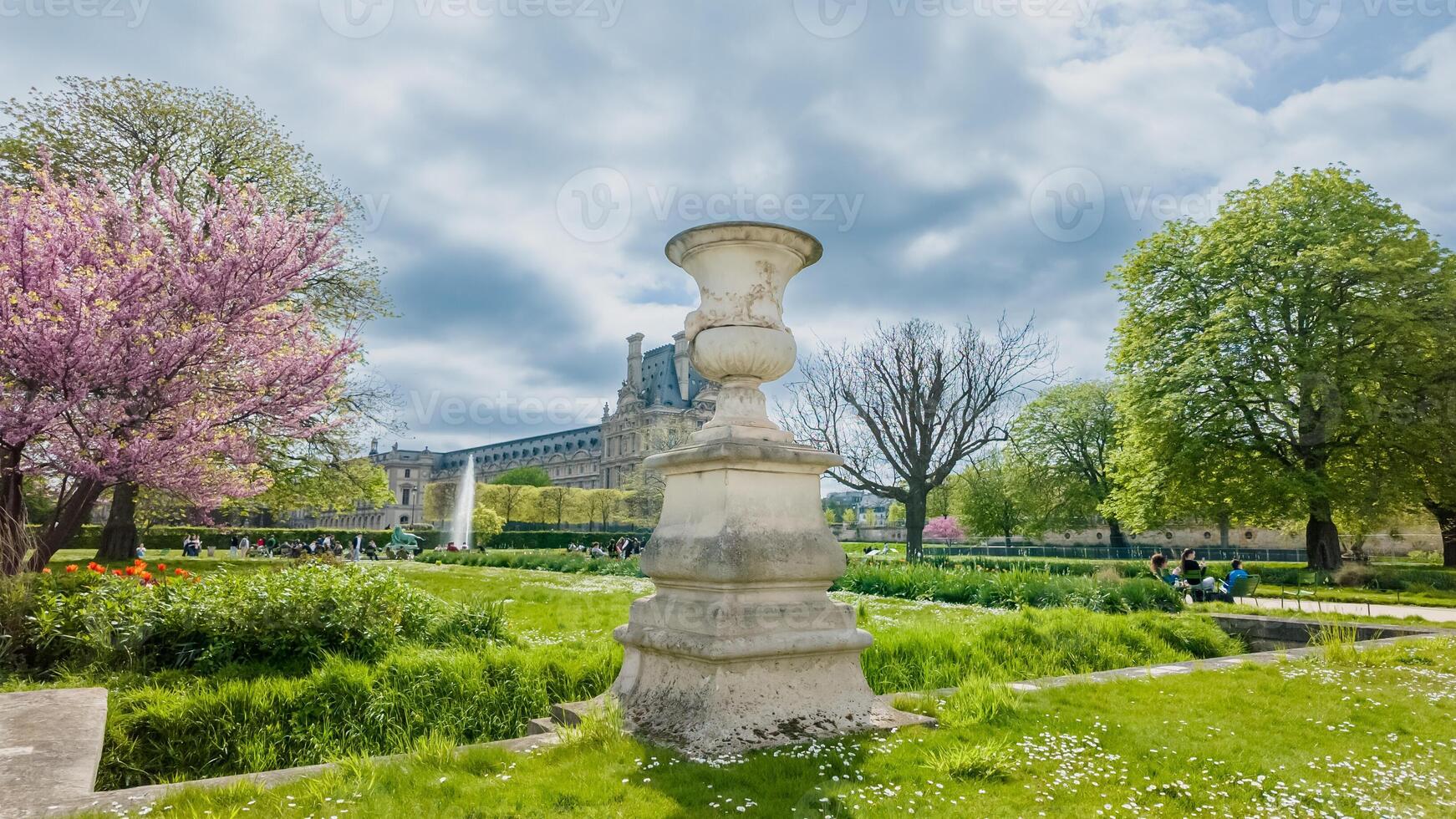 fioritura primavera giardino con classico pietra urna nel primo piano e storico europeo palazzo nel il sfondo, evocando Pasqua e europeo eredità giorni foto