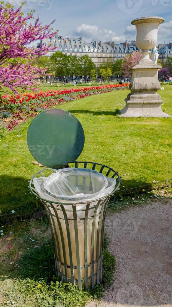 pubblico giardino cestino con un' oscillante coperchio in mezzo fioritura primavera fiori, simboleggiante urbano pulizia e ambientale conservazione sforzi foto