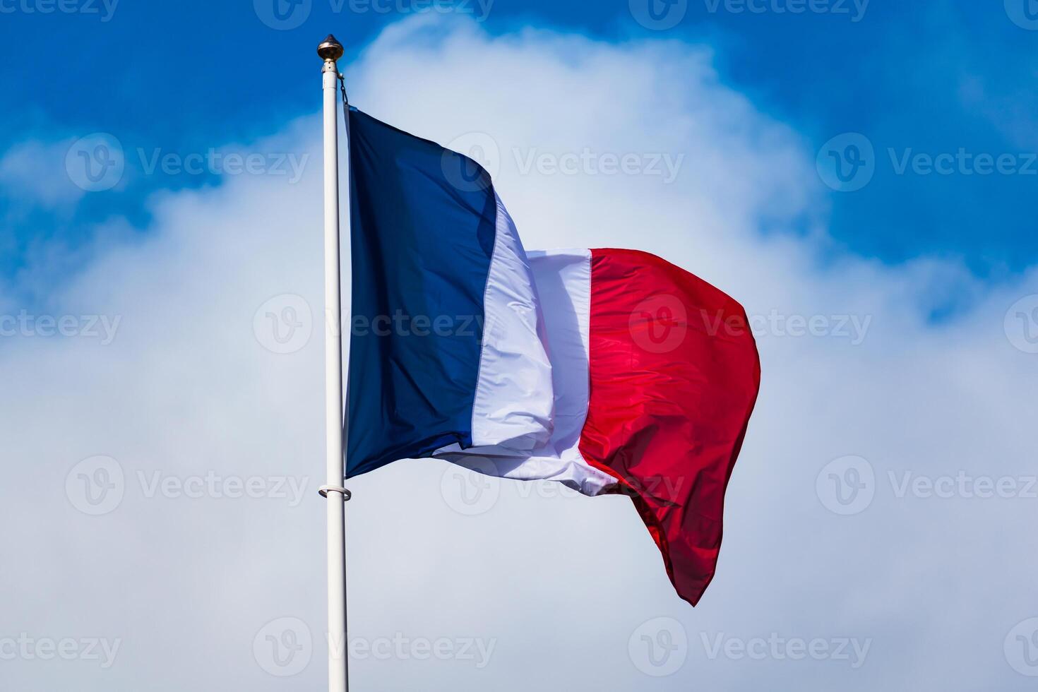 francese tricolore bandiera svolazzanti con forte vento e blu cielo foto