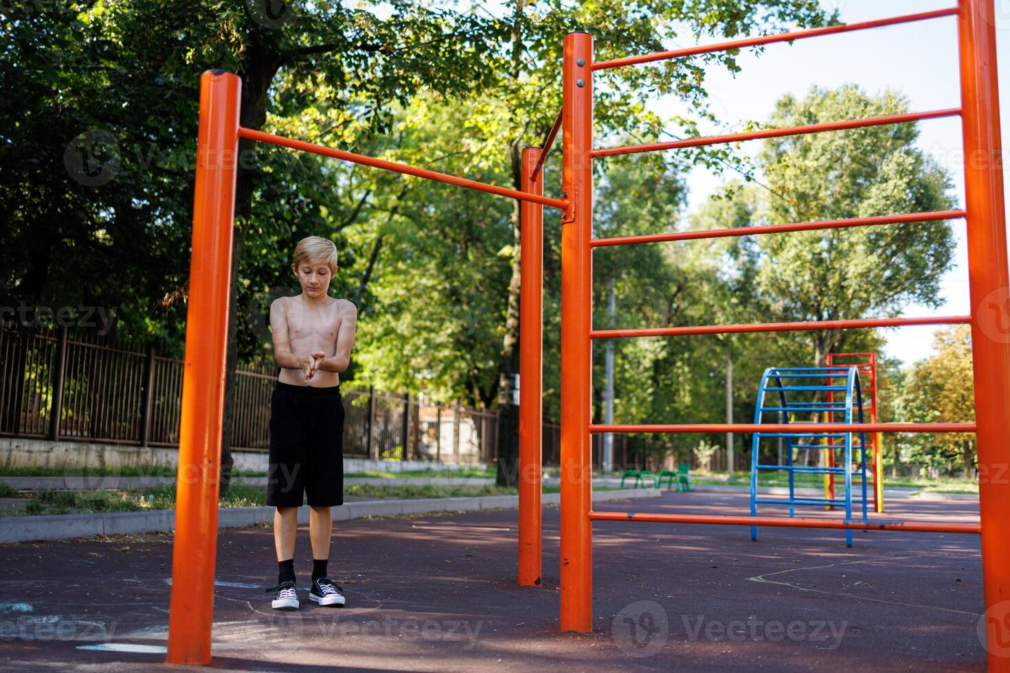 gli sport adolescente strofina il suo palme. strada allenarsi su un' orizzontale bar nel il scuola parco. foto