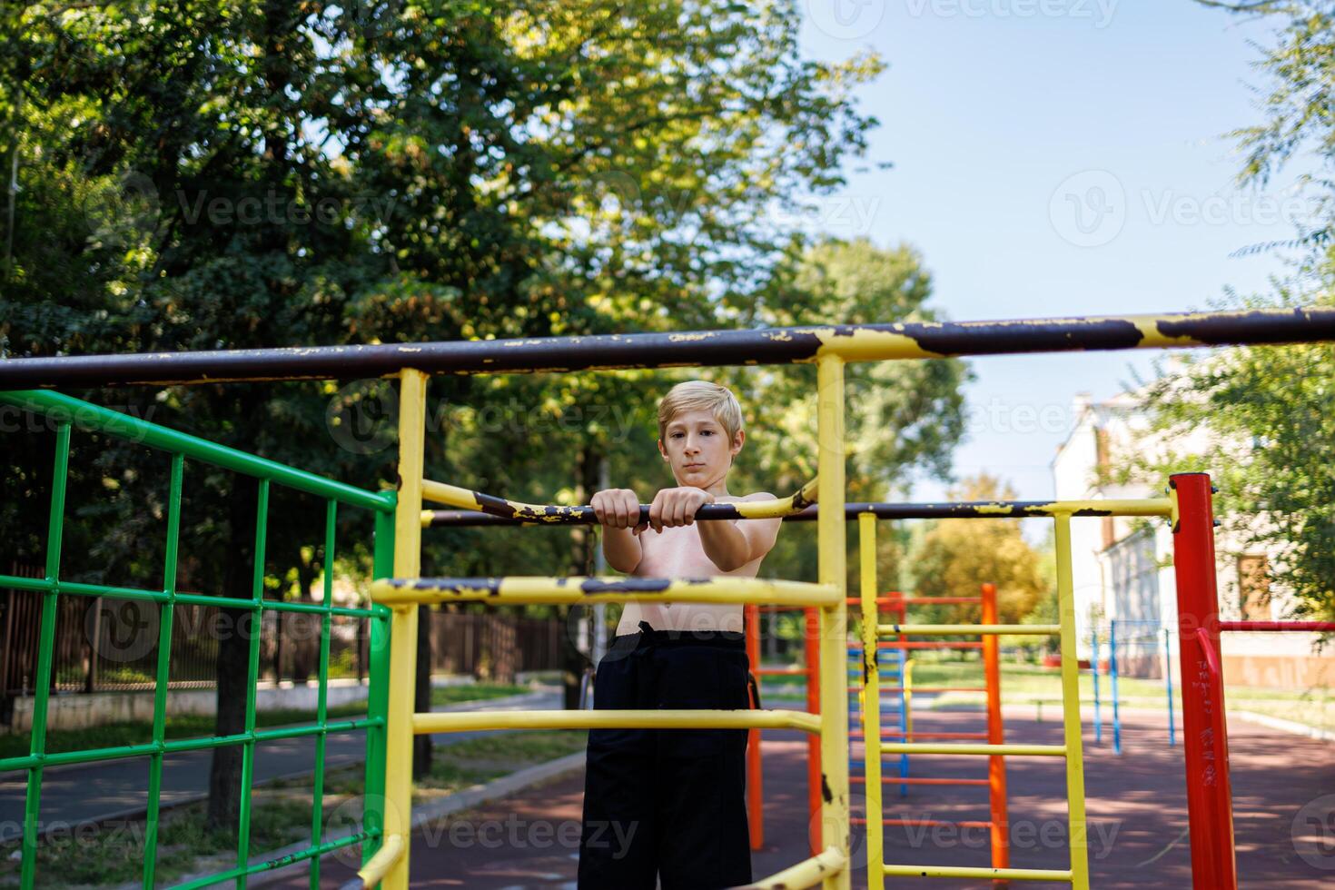 atletico adolescenti su il ginnastica le scale nel il parco. strada allenarsi su un' orizzontale bar nel il scuola parco. foto