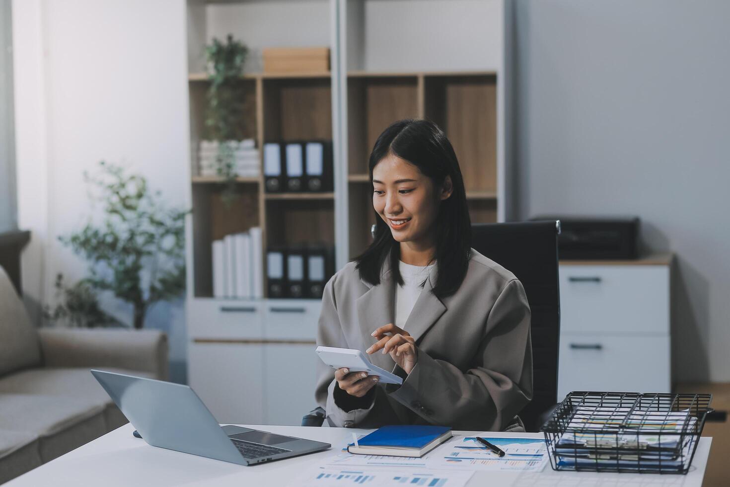 asiatico donna imprenditore utilizzando un' calcolatrice calcolatore finanziario spese a casa ufficio, stampa calcolatrice pulsante finanza analizzando e-payment tecnologia, maniaco di shopping stile di vita, mobile applicazione foto