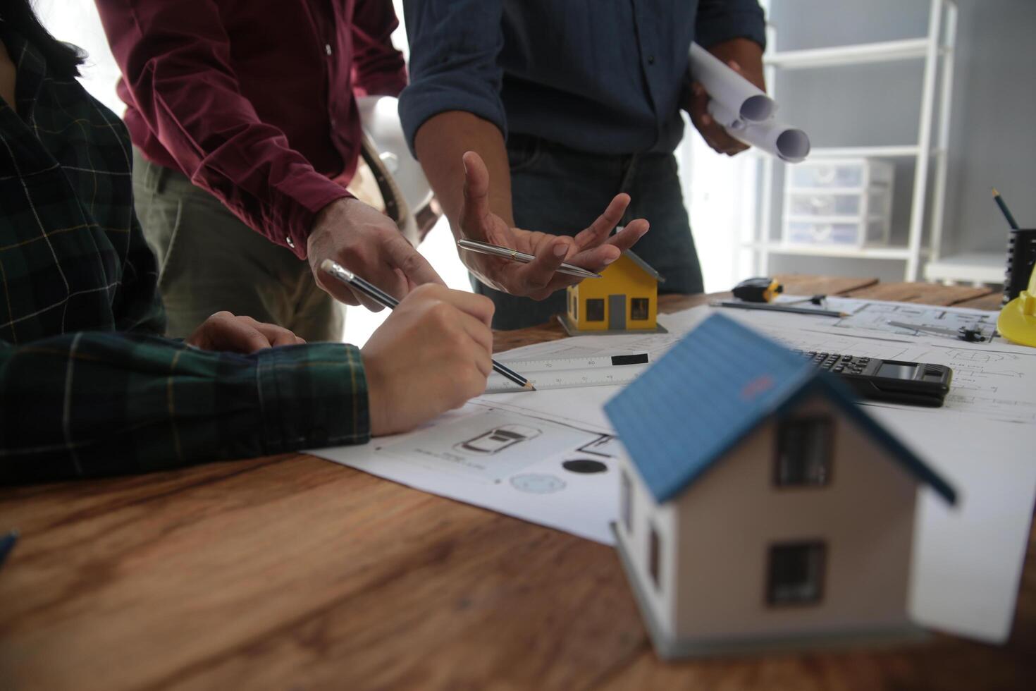 diverso squadra di specialisti uso il computer portatile su costruzione luogo. vero tenuta edificio progetto con ingegnere investitore e uomo d'affari controllo la zona, Lavorando su civile ingegneria, discutere strategia Piano foto