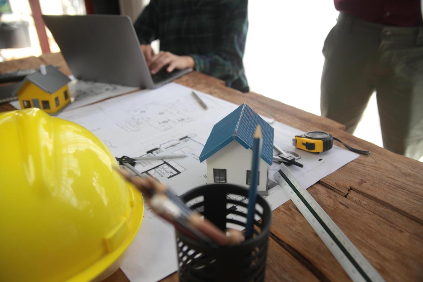 diverso squadra di specialisti uso il computer portatile su costruzione luogo. vero tenuta edificio progetto con ingegnere investitore e uomo d'affari controllo la zona, Lavorando su civile ingegneria, discutere strategia Piano foto