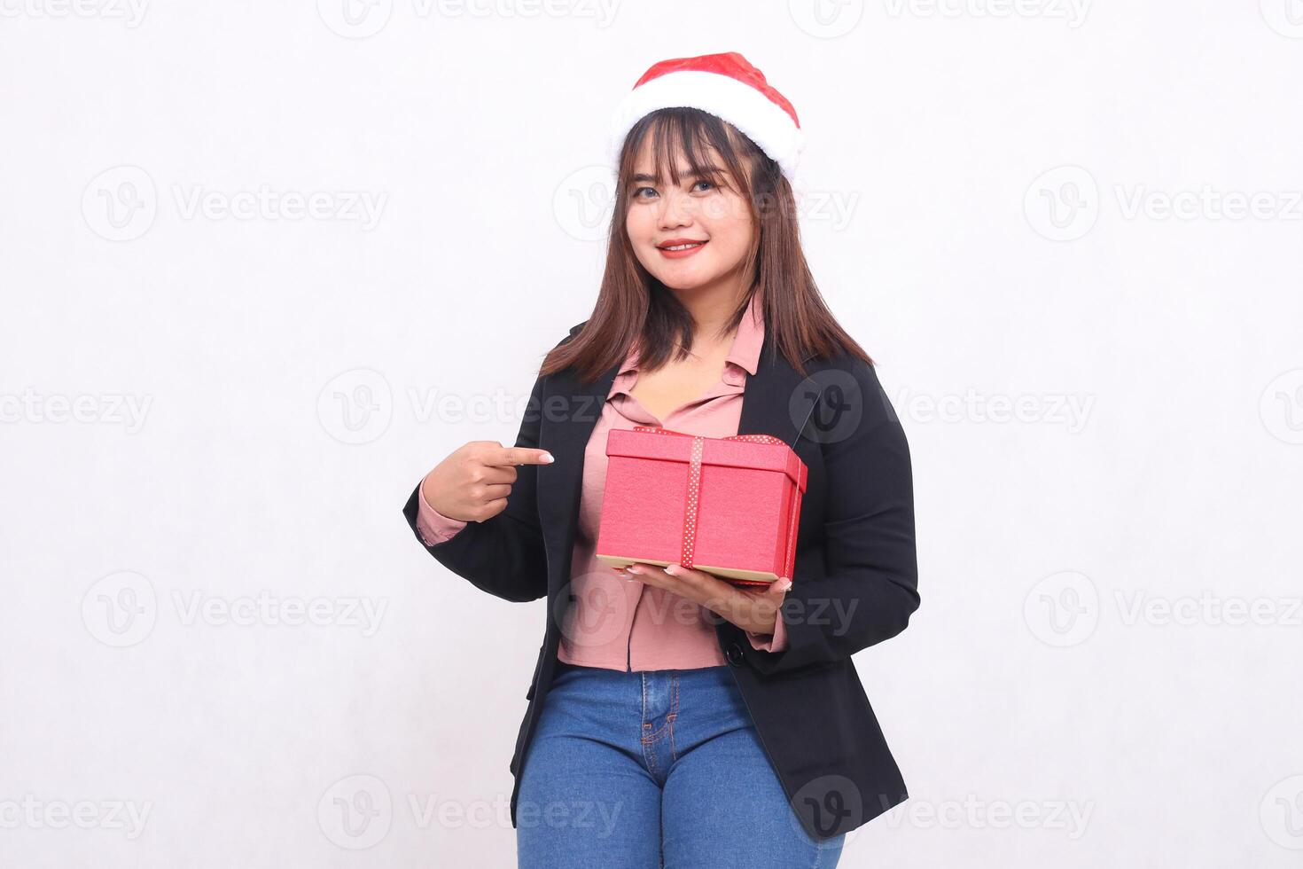 bellissimo asiatico ragazza nel allegro completo da uomo con Santa Claus cappello in posa con Natale regalo scatola e mano mostrando regalo su bianca sfondo per promozione, pubblicità, striscione, tabellone foto