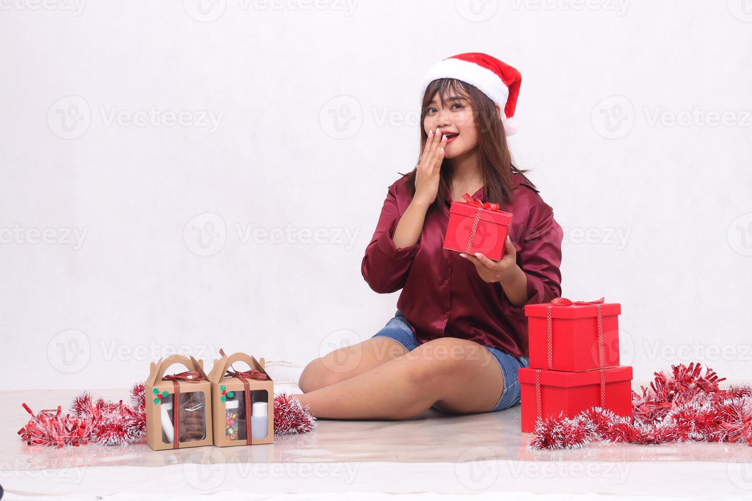 bellissimo giovane sud-est asiatico ragazza sorpreso per ridere trasporto scatola Il prossimo per 3 regalo scatole di ostacola a Natale indossare Santa fascia per capelli e rosso camicia su bianca sfondo per promozione e pubblicità foto