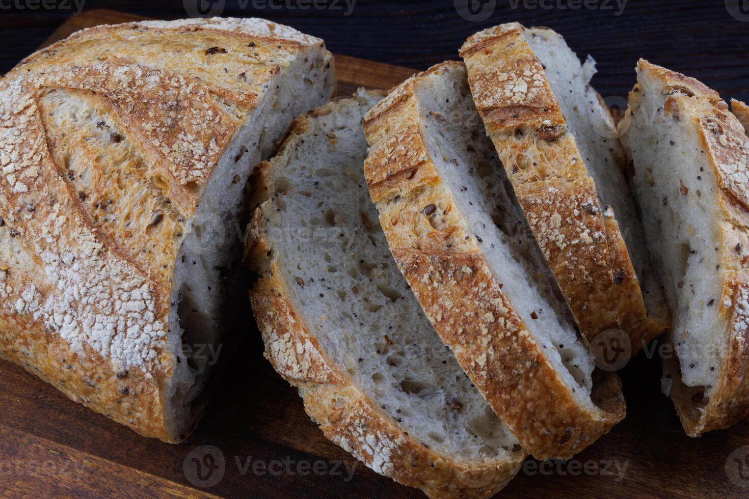 tagliare pagnotta con semi su un' di legno tavola. affettato pezzi di pane. arte pane. foto