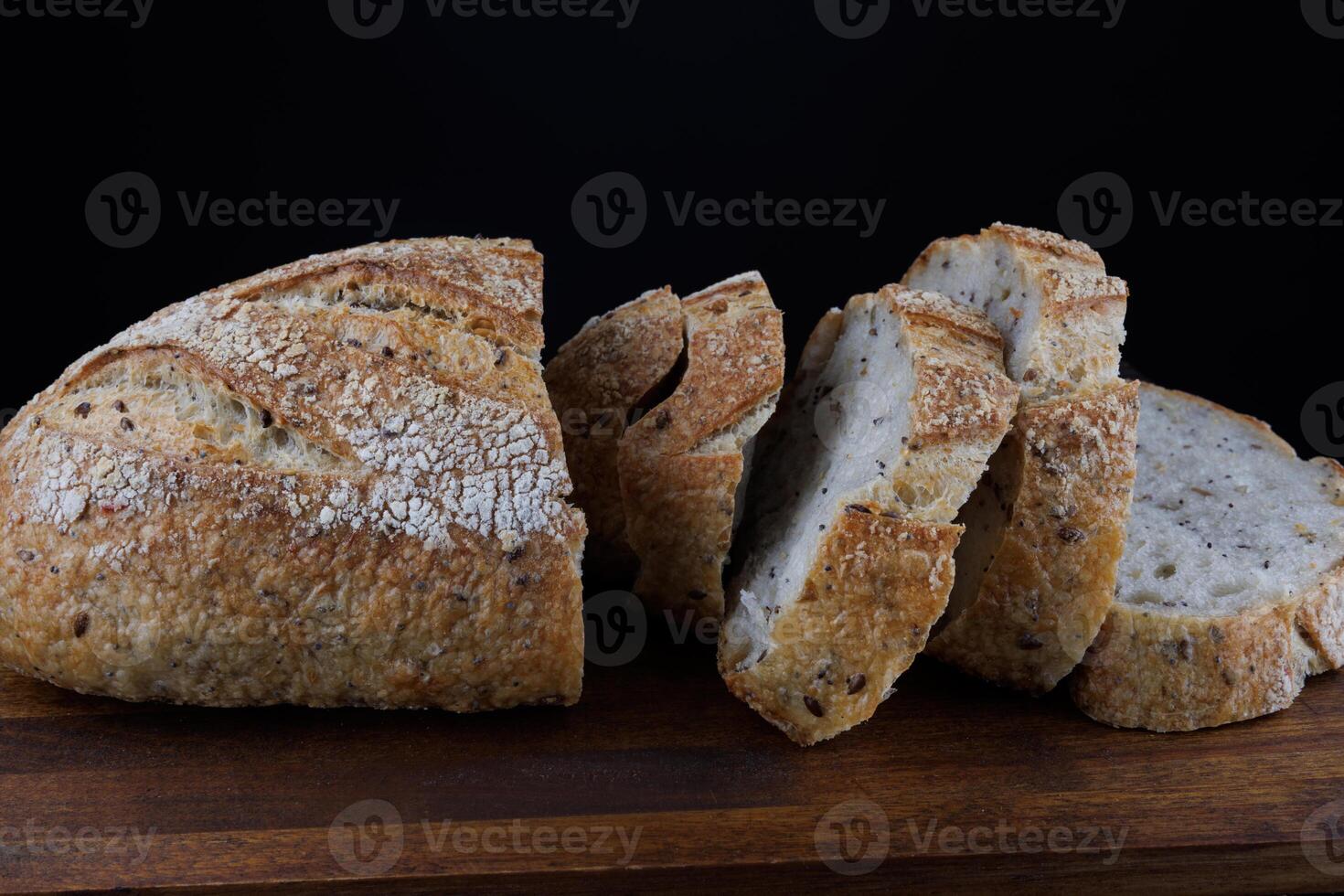 tagliare pagnotta con semi su un' di legno tavola. affettato pezzi di pane. arte pane. foto