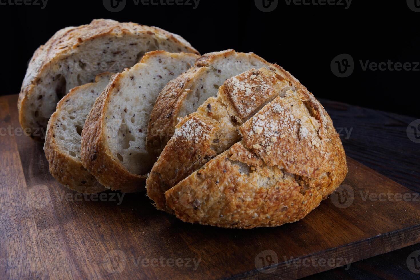 tagliare pagnotta con semi su un' di legno tavola. affettato pezzi di pane. arte pane. foto