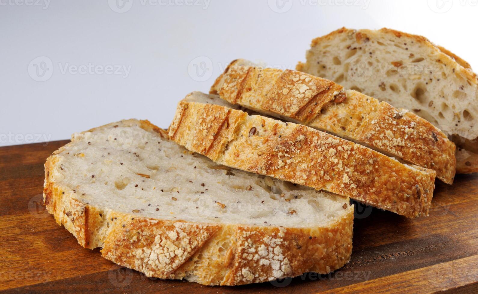 tagliare pagnotta con semi su un' di legno tavola su un' bianca sfondo. affettato pezzi di pane. arte pane. foto