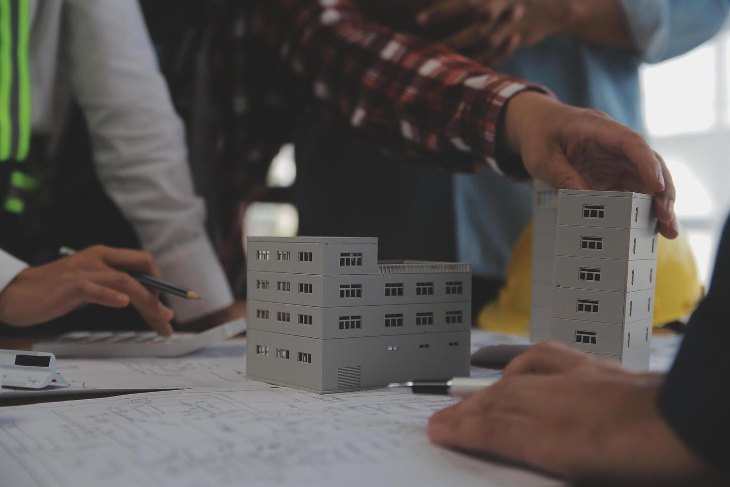 costruzione e struttura concetto di ingegnere o architetto incontro per progetto Lavorando con compagno e ingegneria utensili su modello edificio e planimetria nel Lavorando luogo, contrarre per tutti e due aziende. foto