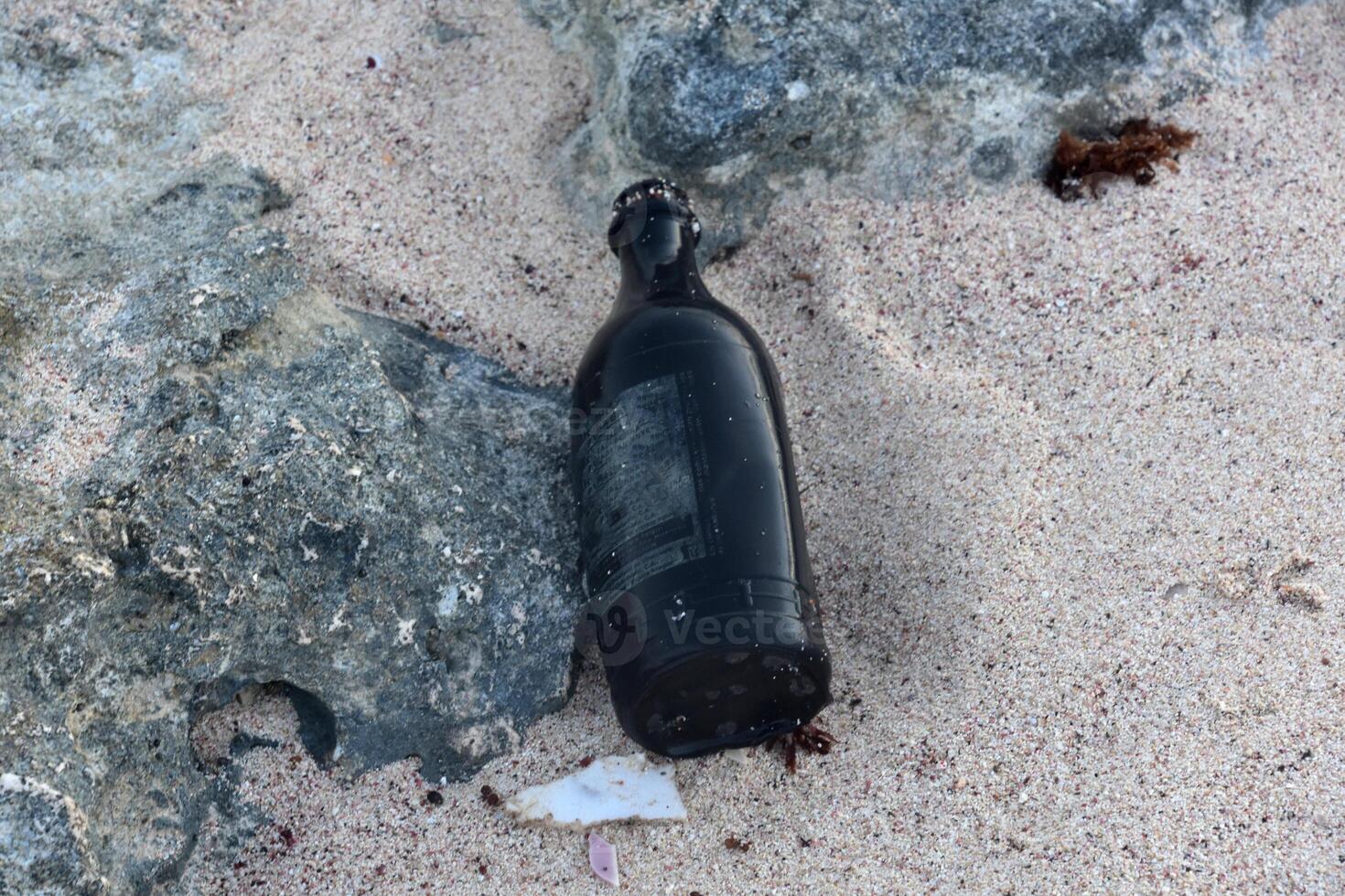 bottiglia trovato scartato su un' spiaggia nel il sabbia foto