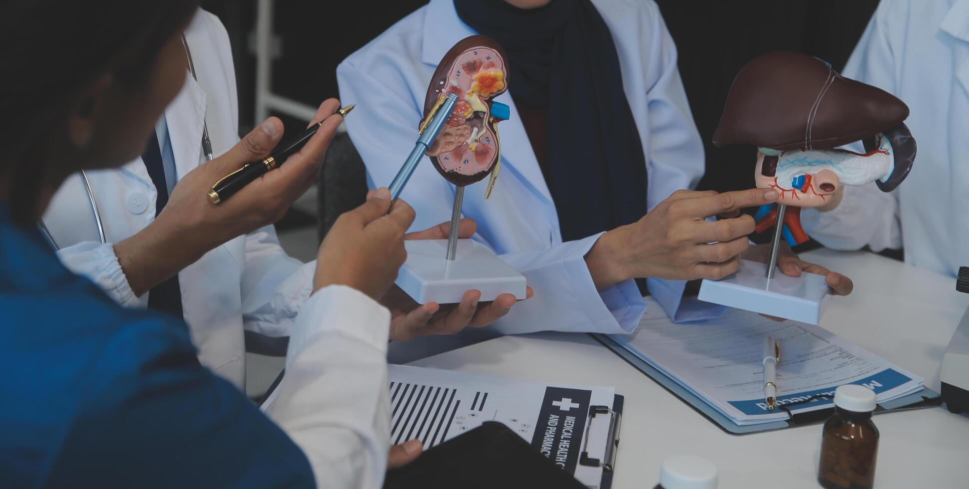 medico, incontro e il computer portatile per squadra nel ufficio nel discussione, di brainstorming e pianificazione. medico, infermiera e computer su scrivania, lavoro di squadra o laboratorio per modello interno organo. foto