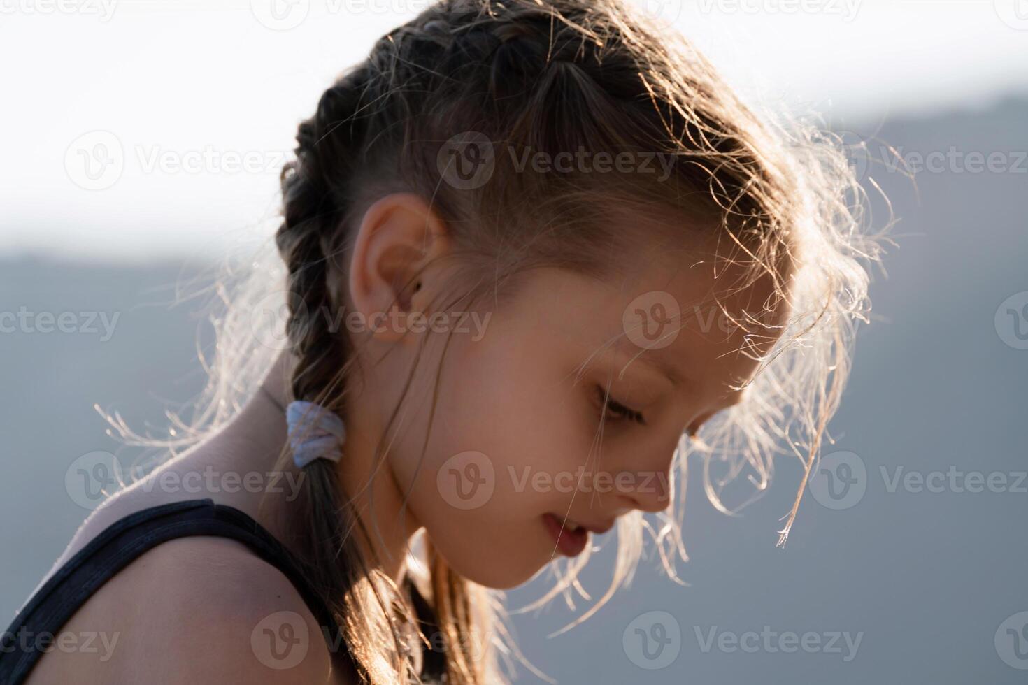 un' giovane ragazza con intrecciato capelli è guardare a il telecamera foto