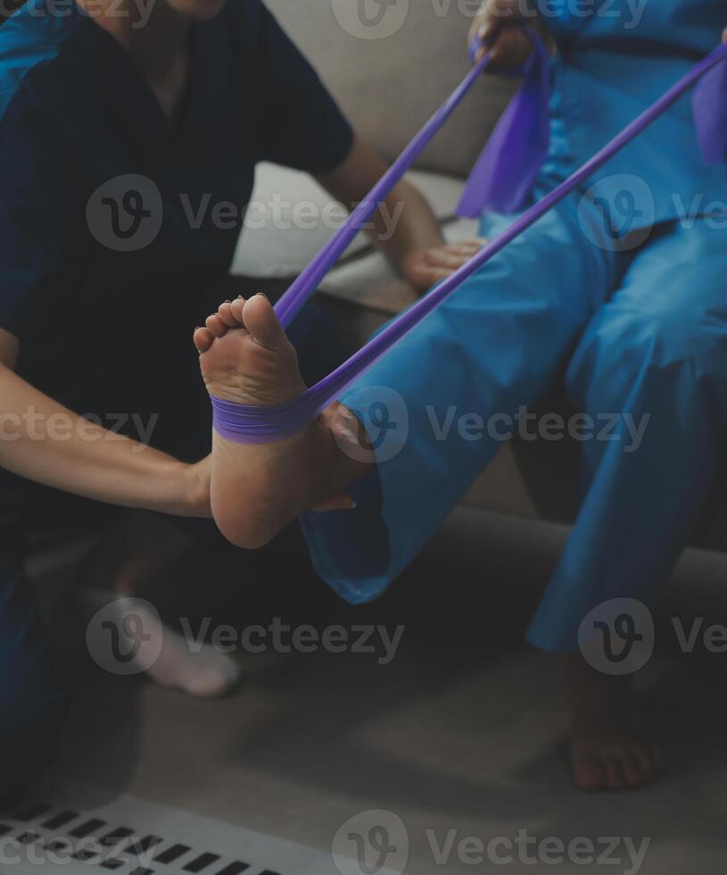irriconoscibile anziano fisioterapista Lavorando con un' femmina paziente. foto