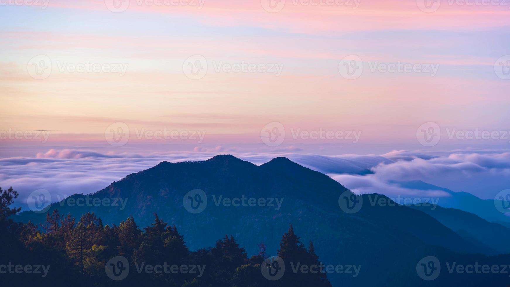 Valle della nebbia di montagna durante l'alba.lo sfondo della natura con la nebbia sulla montagna, in caso di pioggia in campagna foto
