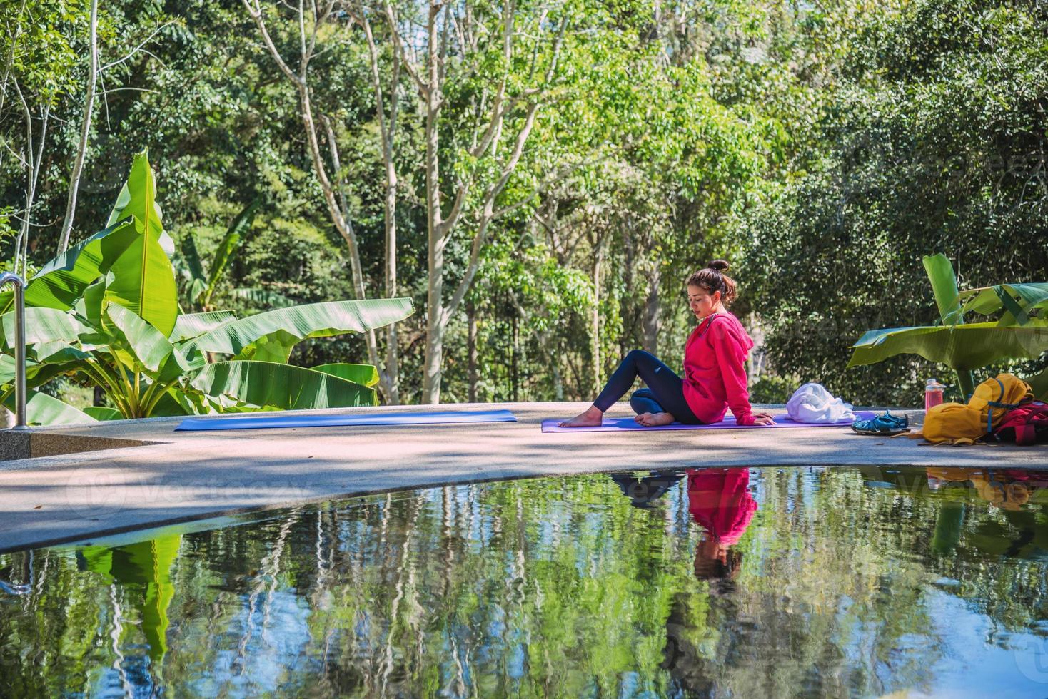 la donna di stile di vita delle vacanze estive si rilassa vicino alla piscina, il concetto di giovani donne negli esercizi di yoga, il viaggio si rilassa, si rilassa in mezzo alla natura. foto