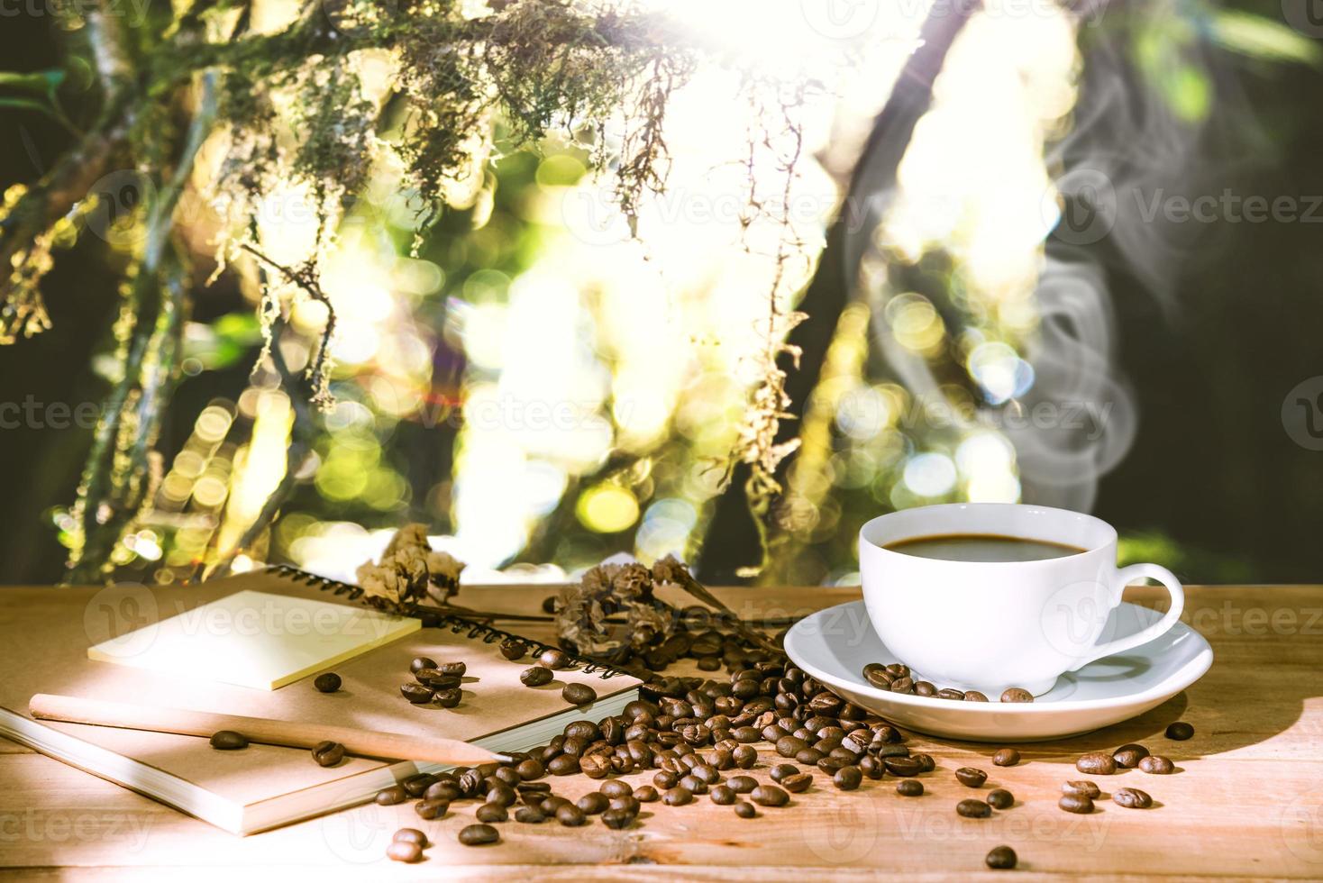 tazza di caffè espresso e chicchi di caffè mattutino, la natura dello sfondo sfocata foto