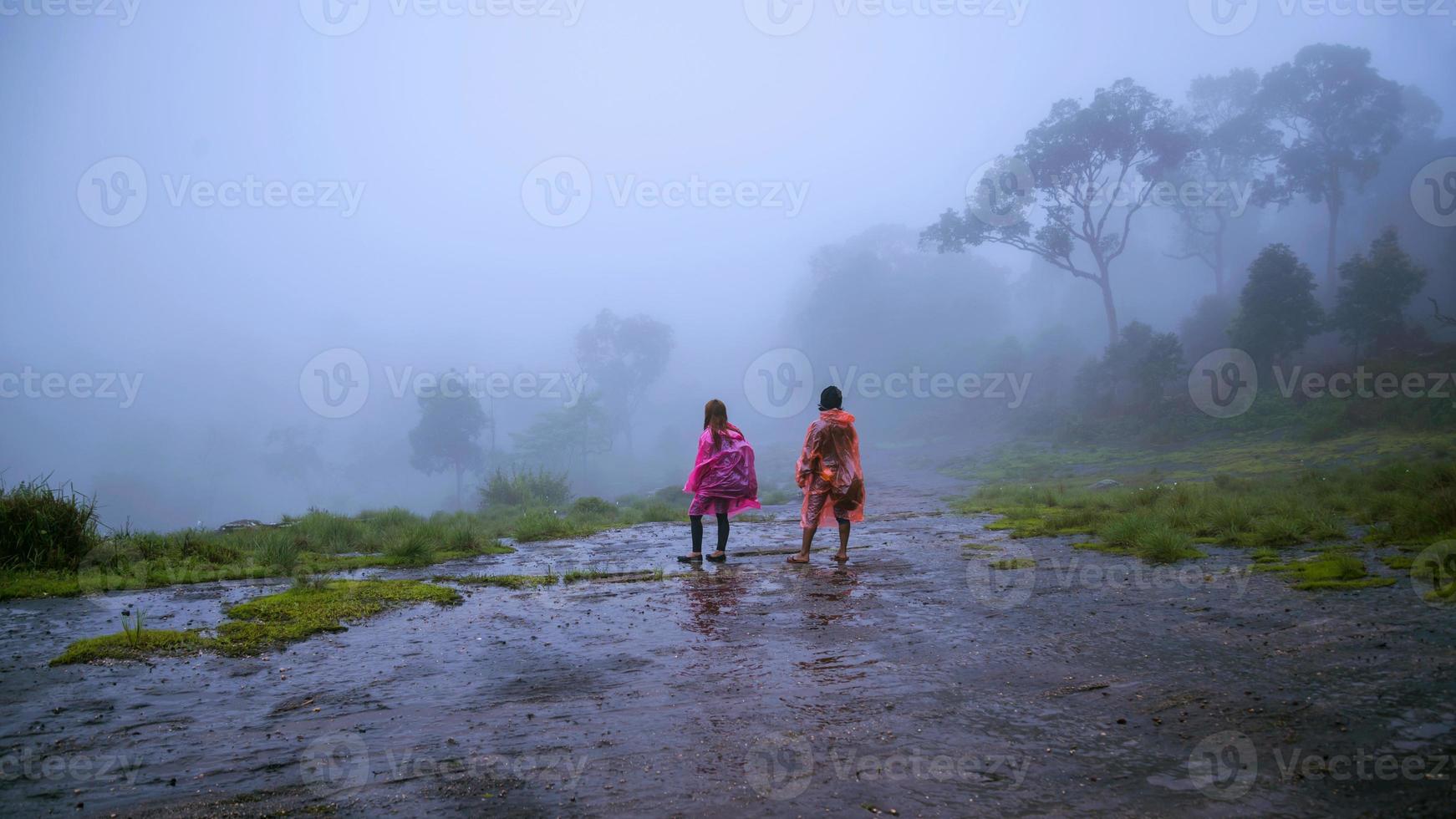 coppie turistiche con impermeabile a piedi viaggio avventura natura nella foresta pluviale. viaggio natura, viaggio relax, viaggio thailandia, stagione delle piogge, felice, romantico. foto