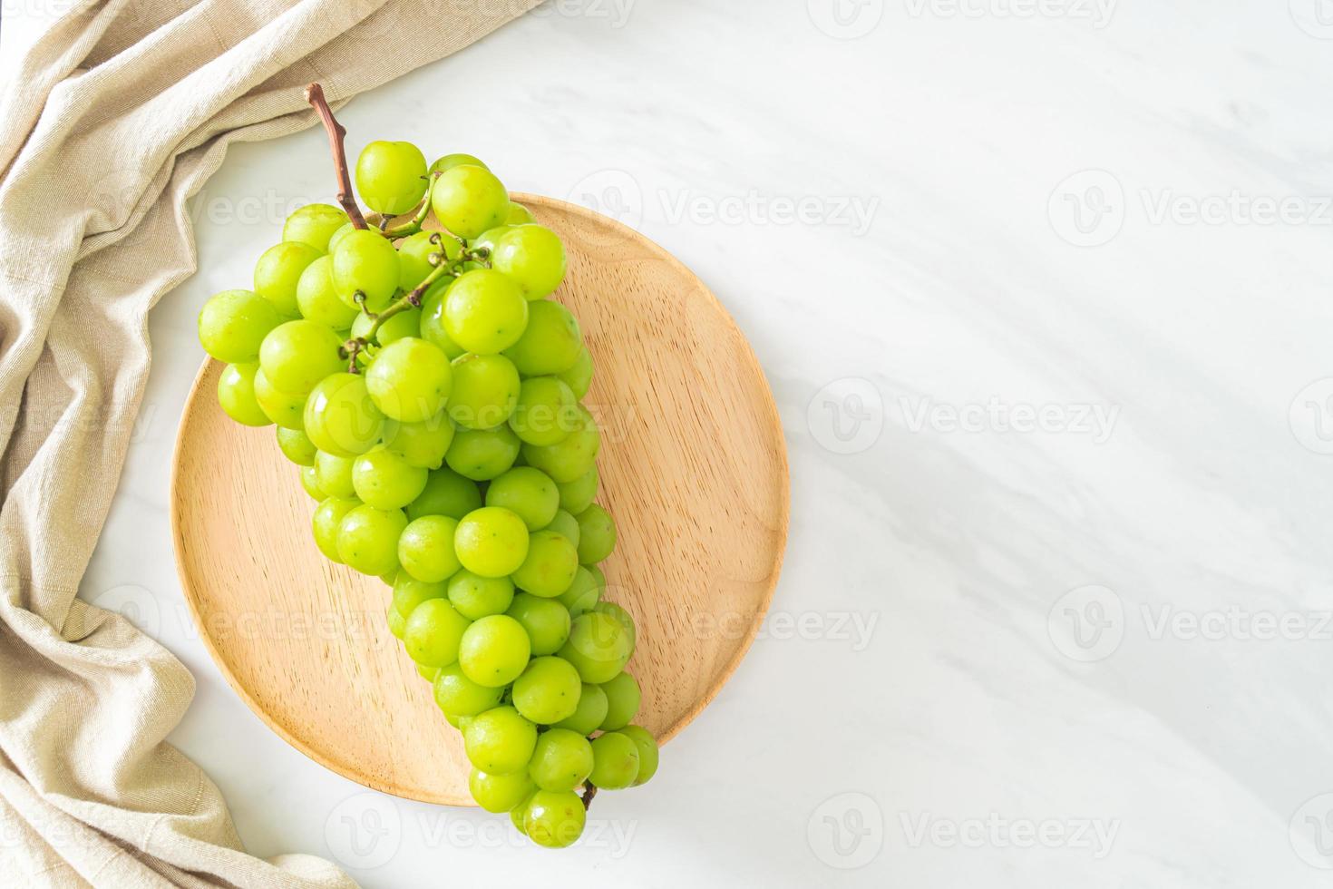 uva verde fresca sul piatto di legno foto