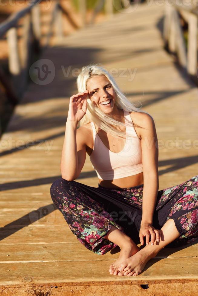 donna sorridente che si gode il tramonto su una bellissima spiaggia foto