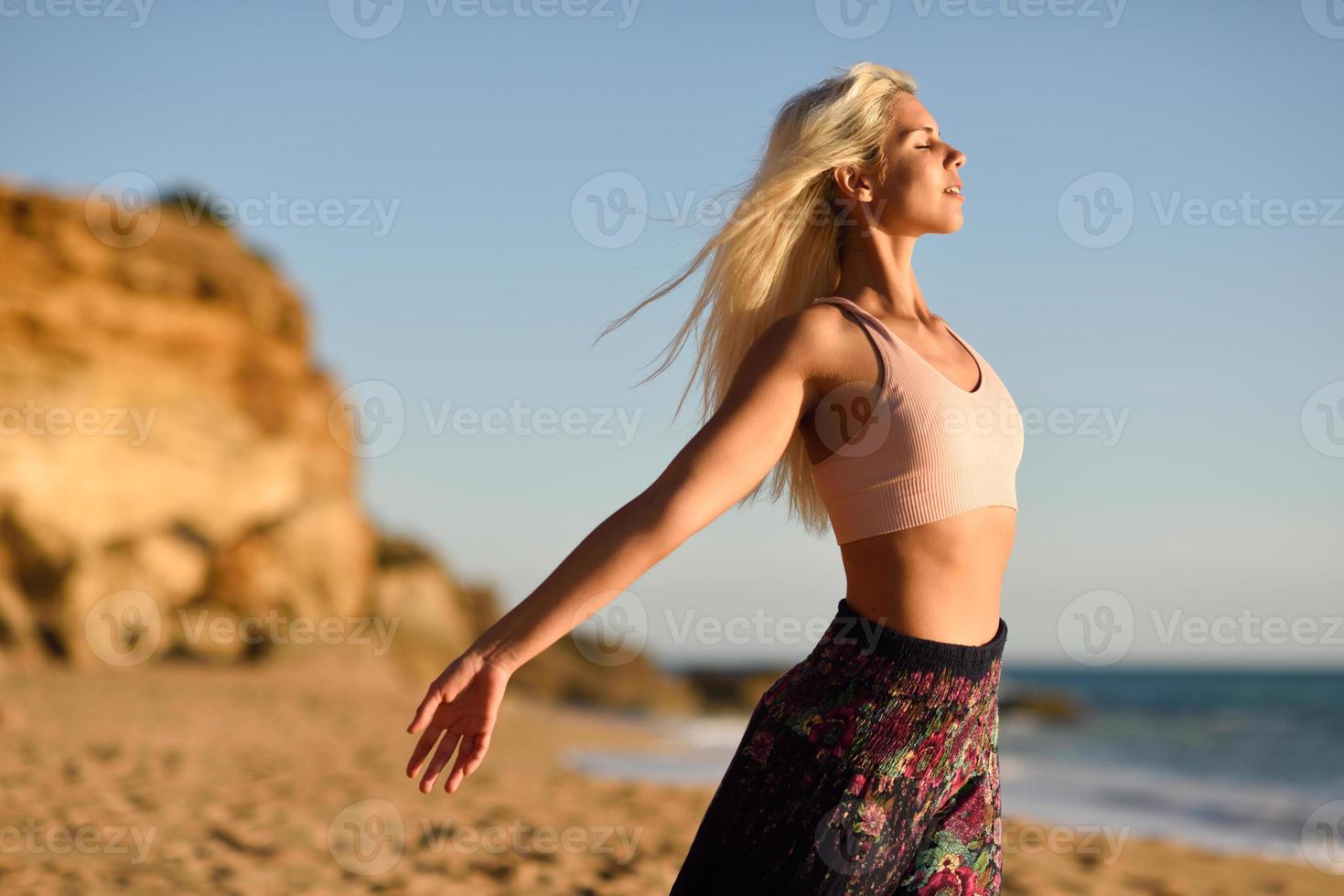 donna che si gode il tramonto su una bellissima spiaggia foto