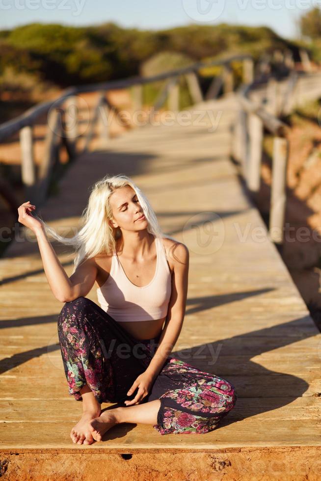 donna sorridente che si gode il tramonto su una bellissima spiaggia foto