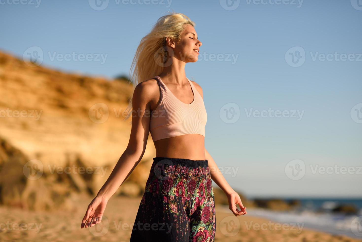 donna che si gode il tramonto su una bellissima spiaggia foto