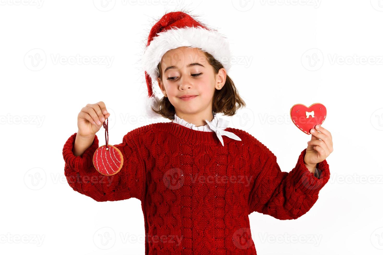 adorabile bambina che indossa un cappello da Babbo Natale con biscotti di Natale foto