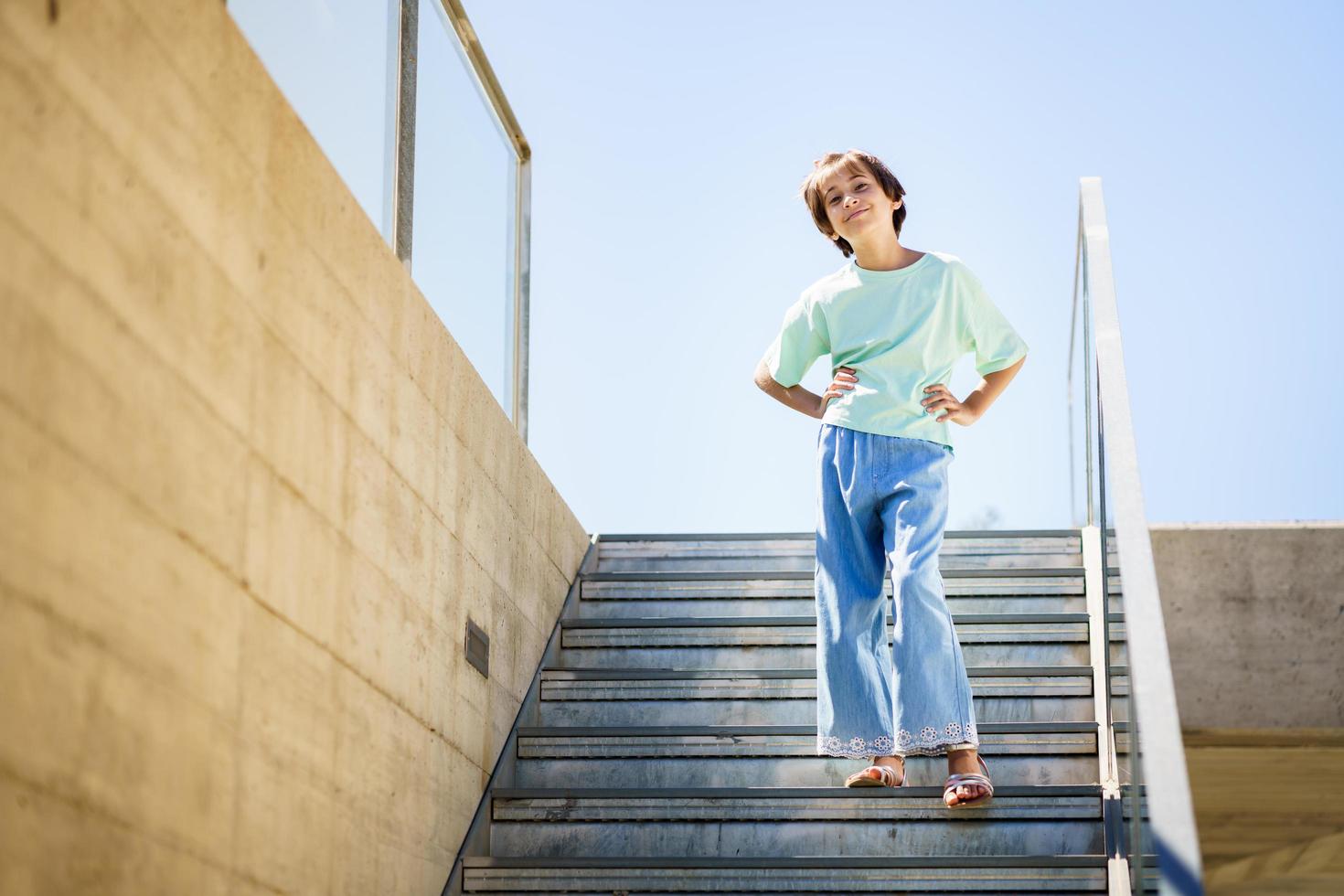 Bambina di 9 anni che posa felicemente su una scala foto