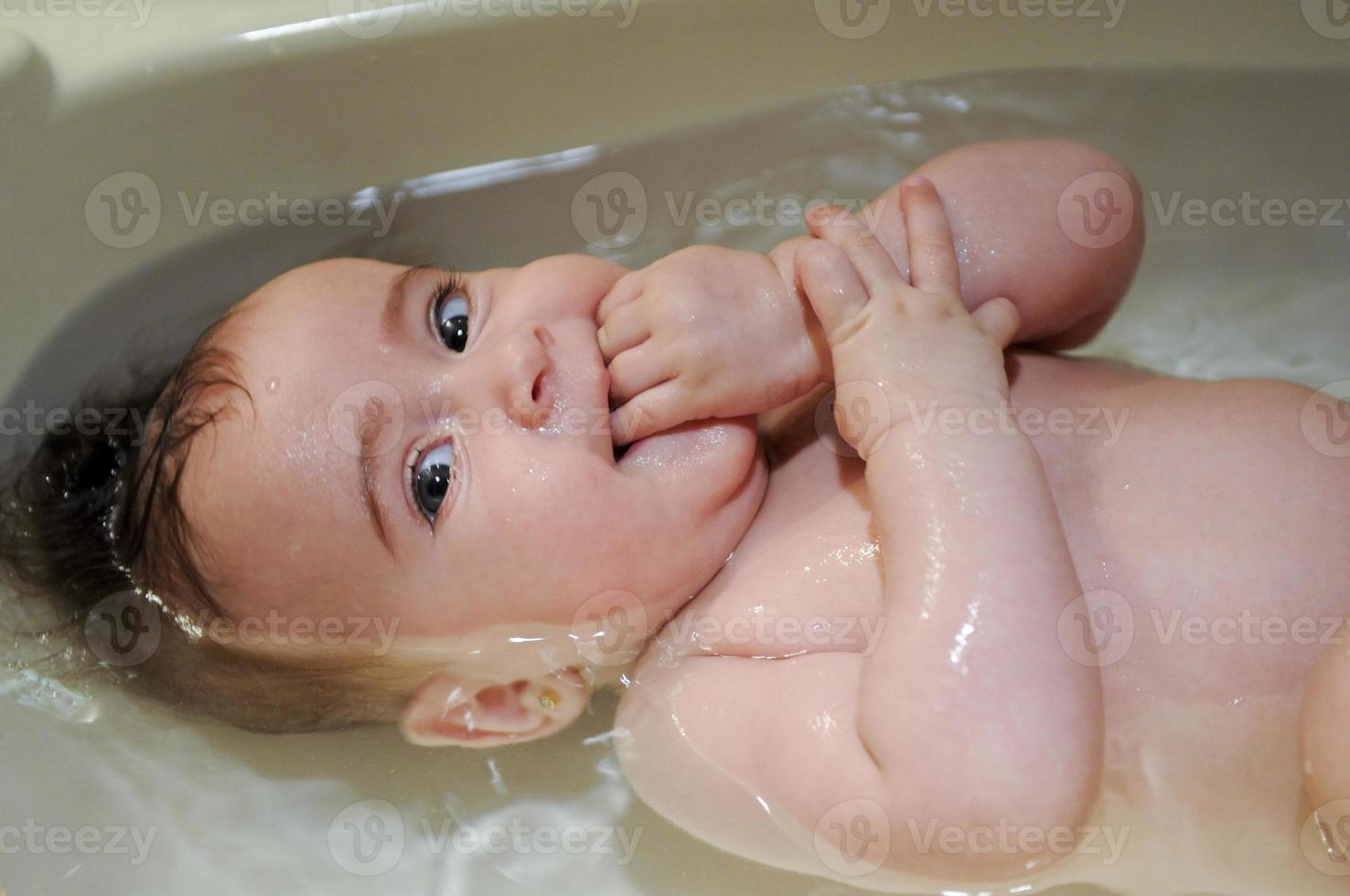 bambina di quattro mesi che fa il bagno foto