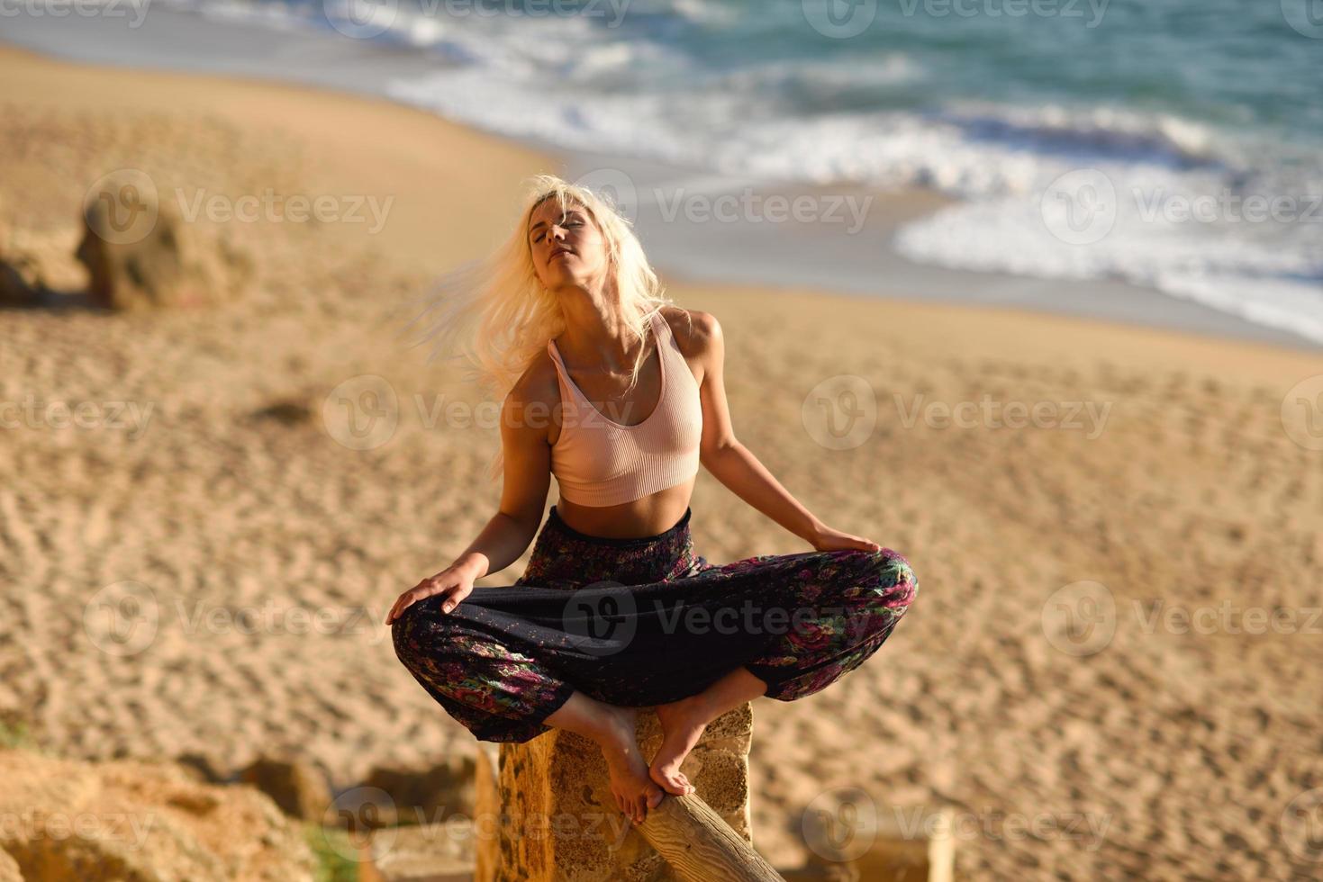 donna che si gode il tramonto su una bellissima spiaggia foto