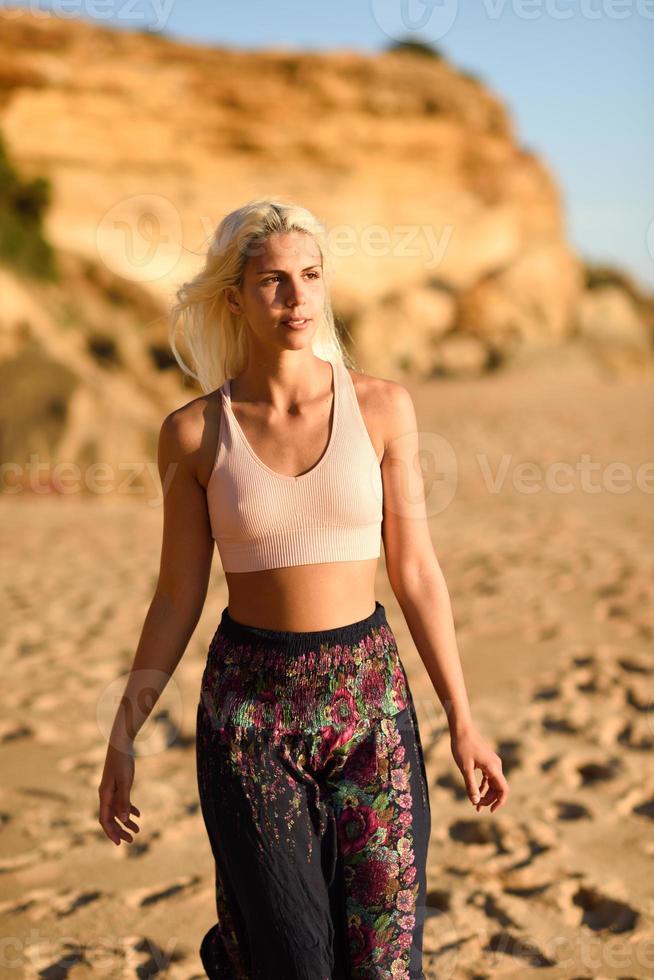 donna che si gode il tramonto su una bellissima spiaggia foto