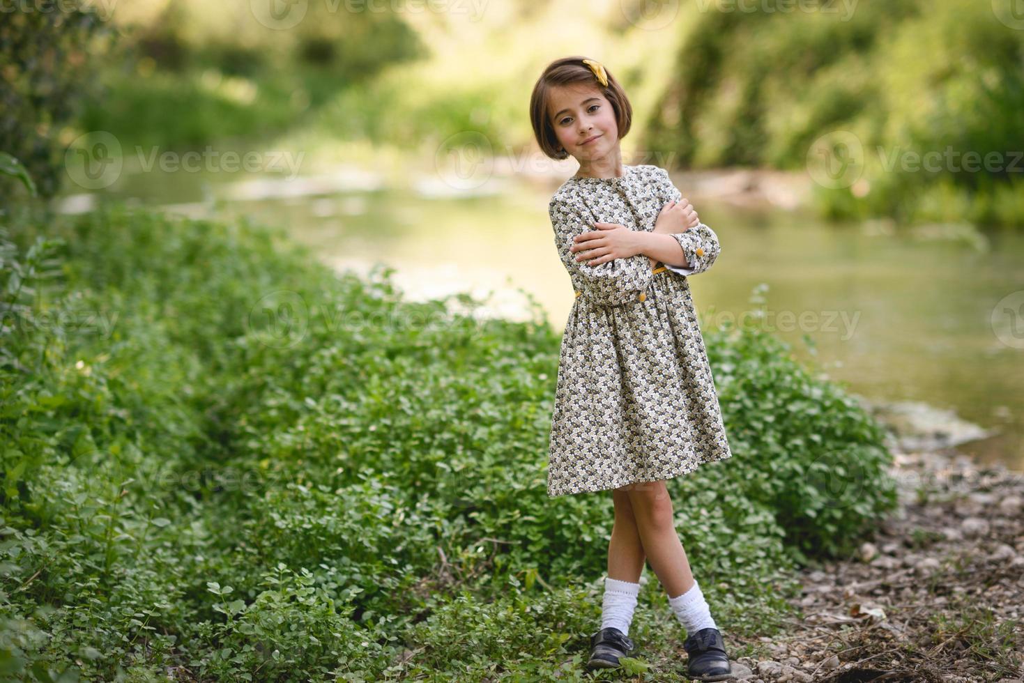 bambina nel flusso della natura che indossa un bel vestito foto