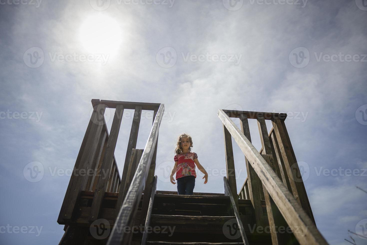 bambina che si arrampica su una torre di osservazione in legno in una zona umida foto