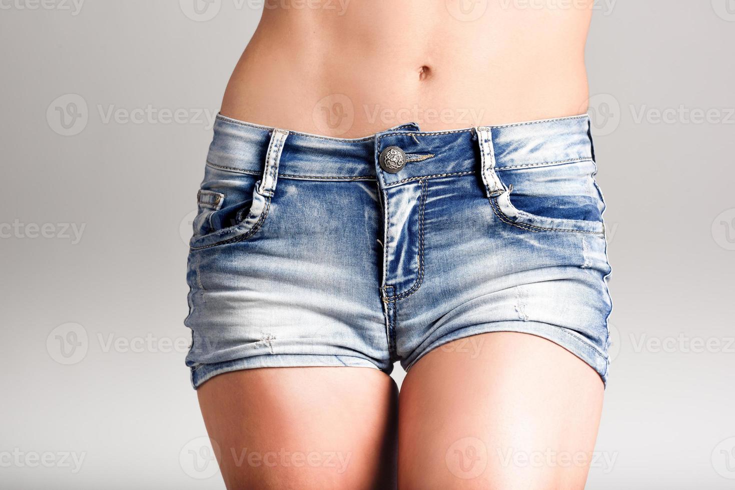 corpo di donna in pantaloncini di jeans denim su sfondo bianco foto