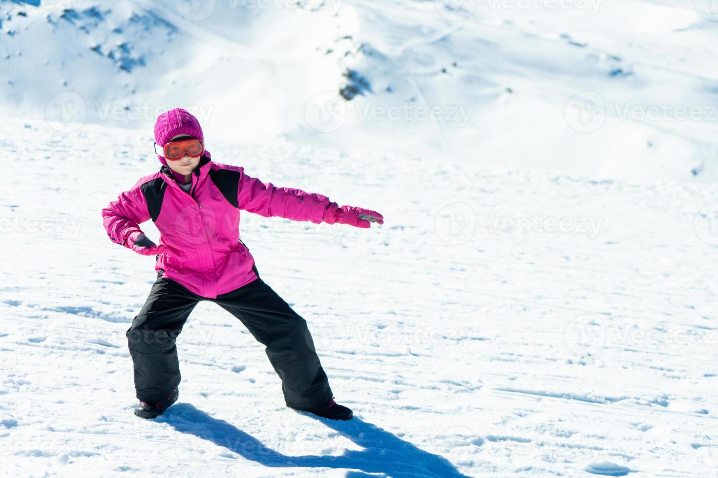 bambina che gioca con l'allenatore di snowboard sulla neve foto