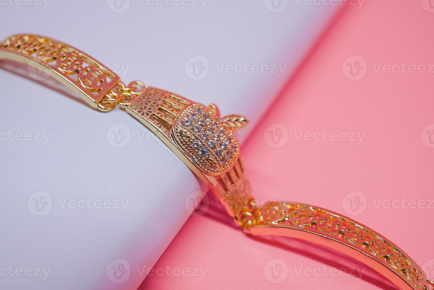 una foto di un braccialetto da donna con motivo a mela su sfondo rosa
