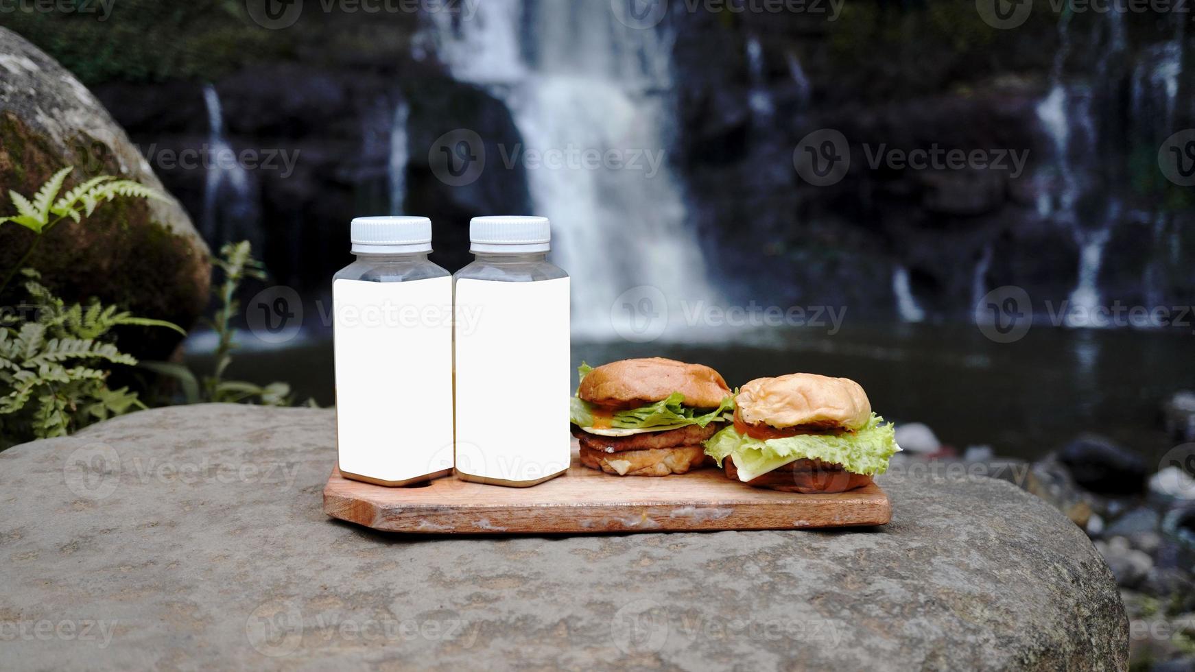 due hamburger e due bottiglie di bibite sul bordo della cascata foto