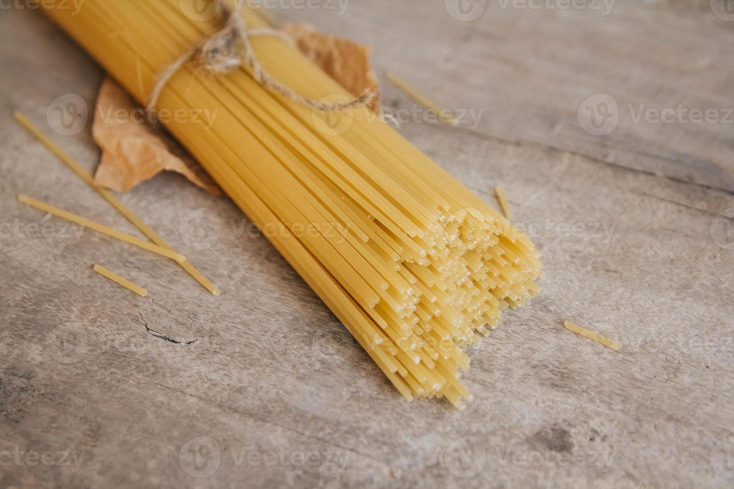 spaghetti lunghi gialli su un vecchio fondo di legno foto