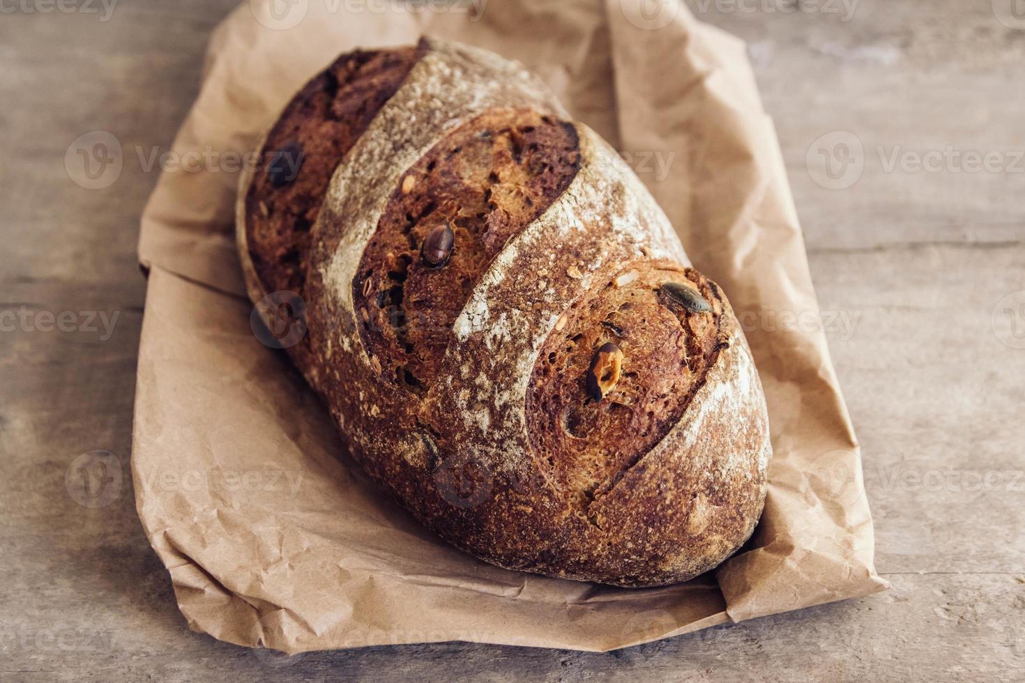 pane fresco marrone con semi su fondo di legno vecchio foto