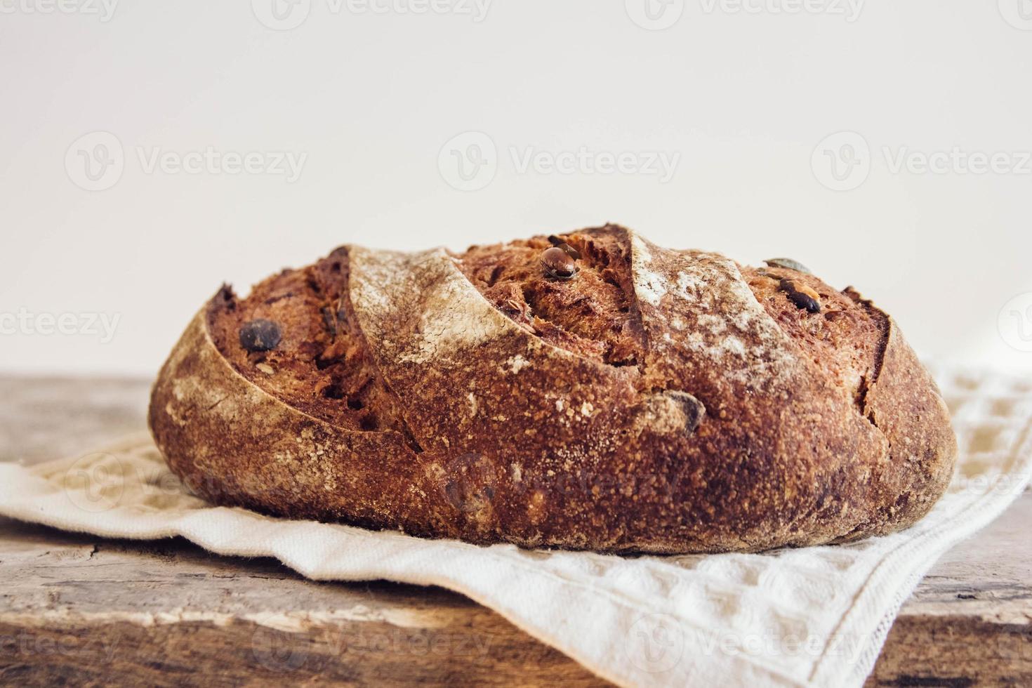 pane fresco marrone con semi su fondo di legno vecchio foto